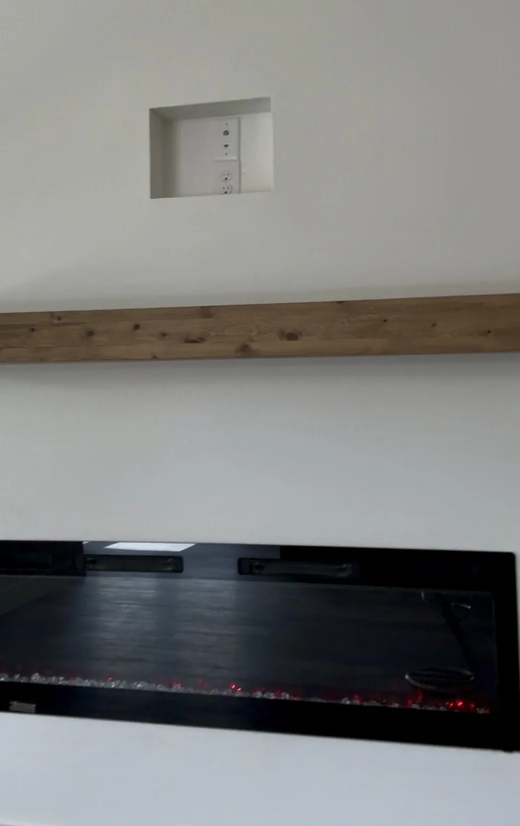 Built-in linear fireplace with a distressed wood mantel