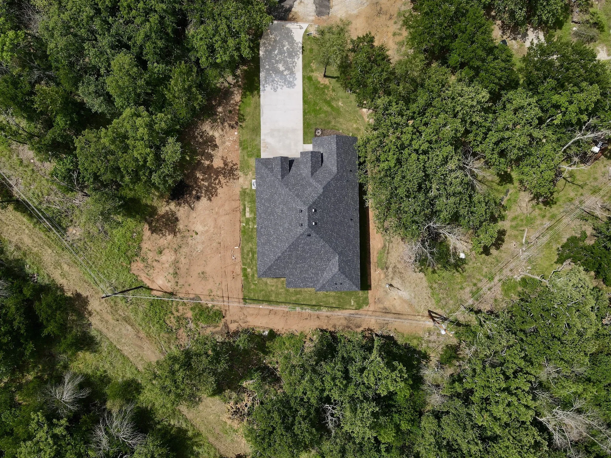 New construction home featuring a dark shingle roof and a concrete driveway