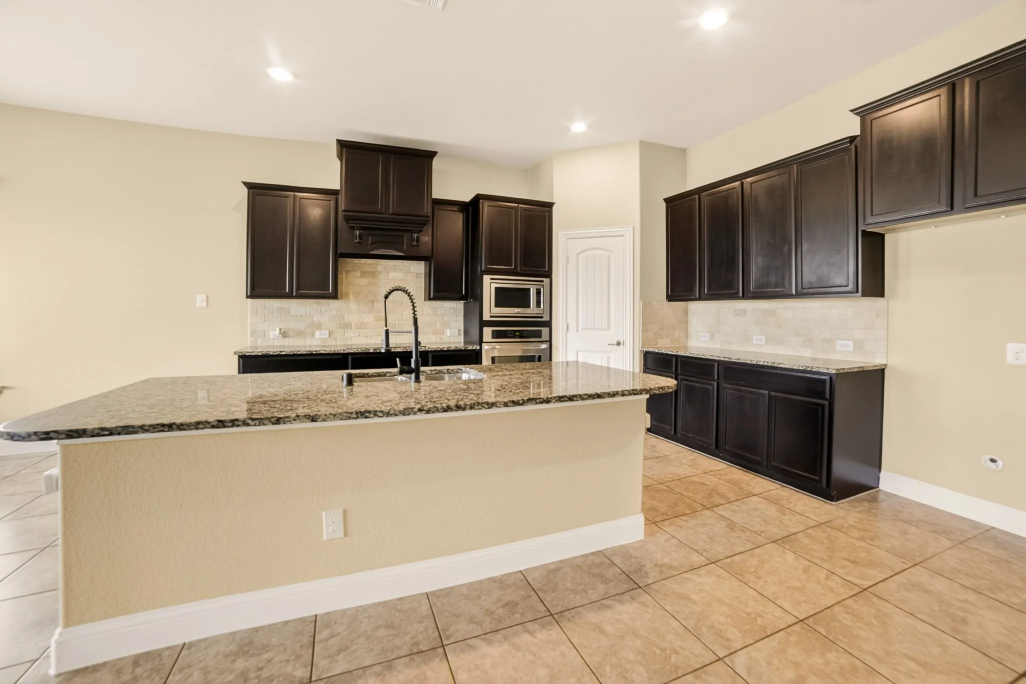 view of kitchen from the butlers pantry cabinets shows how large the break bar counter is that easily seats 4