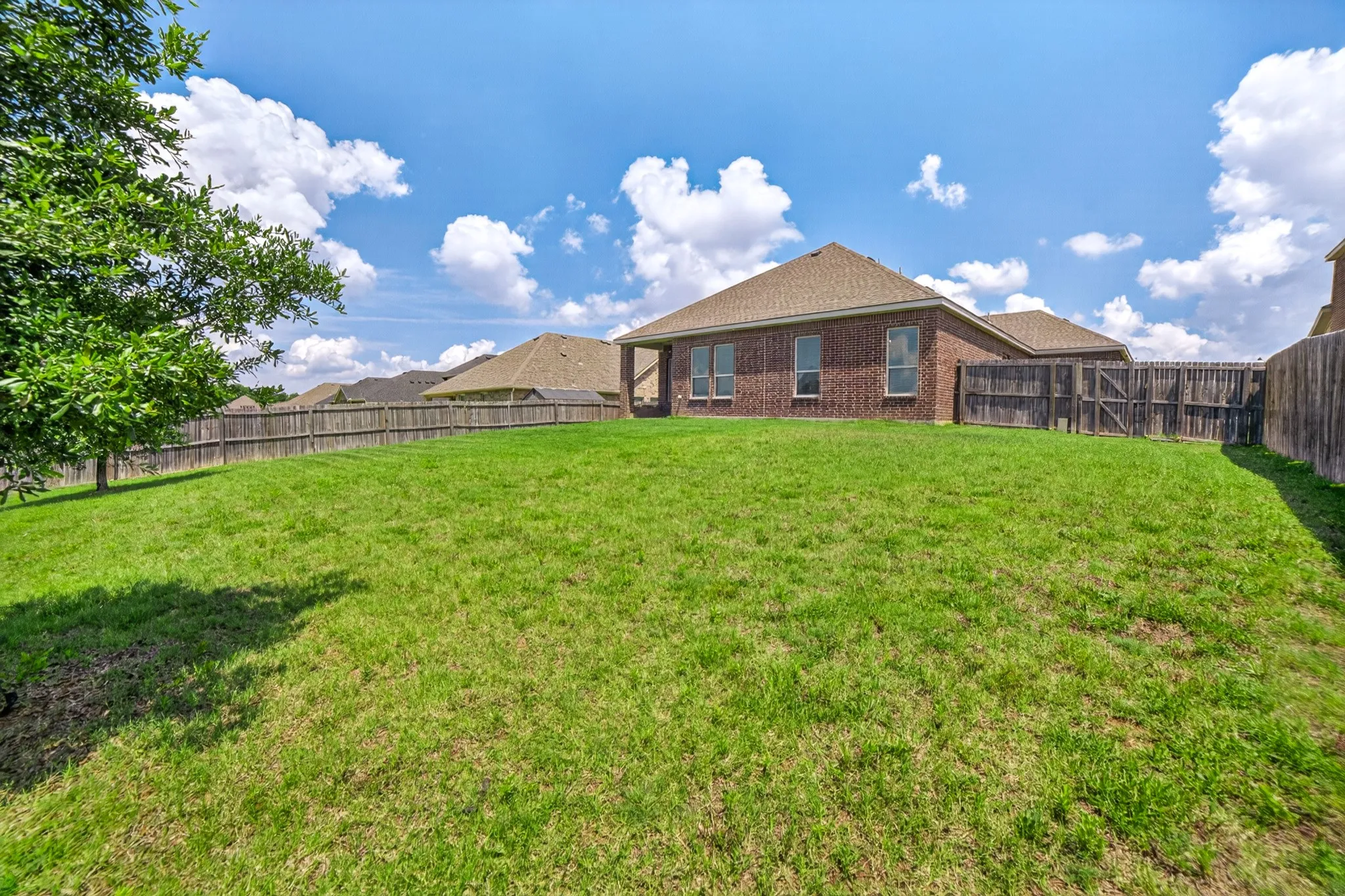 Large backyard with view from the back southeast corner....the wood fence on the right has a gate that leads to front and side yard that's hidden from front and back with shed and area for trash cans which still has room to plant and out of view vegetable garden