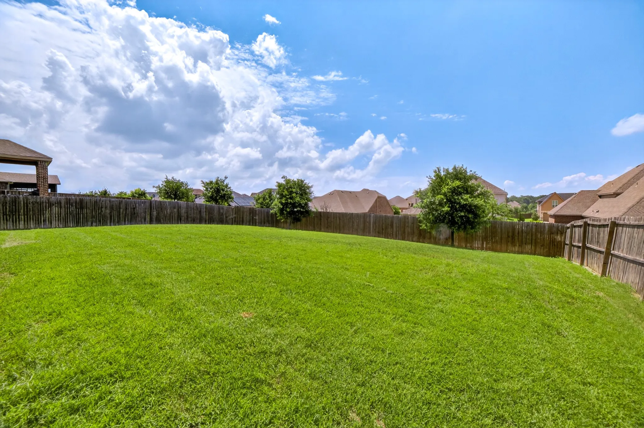 Back yard view from covered patio shows yard is not just wide its deep for extra play and relaxation