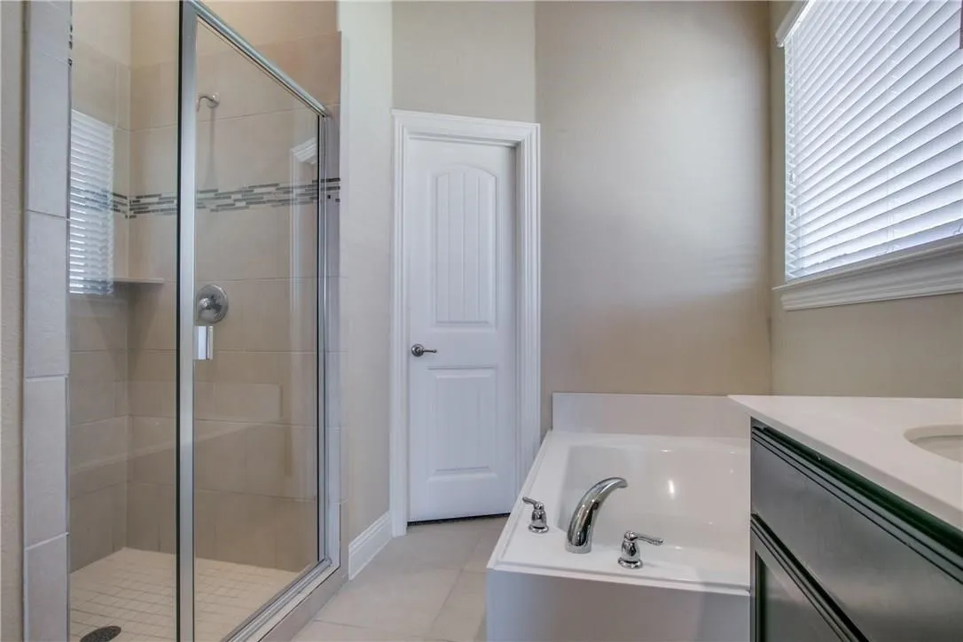 Luxurious master bathroom  with 7ft long double sink vanity , large upgraded garden tub with builtin armrests and recliner slant to relax on, closet door leads to hug master closet, big walkin closet with room for 2, door on left not show before shower goes to privacy toilet area