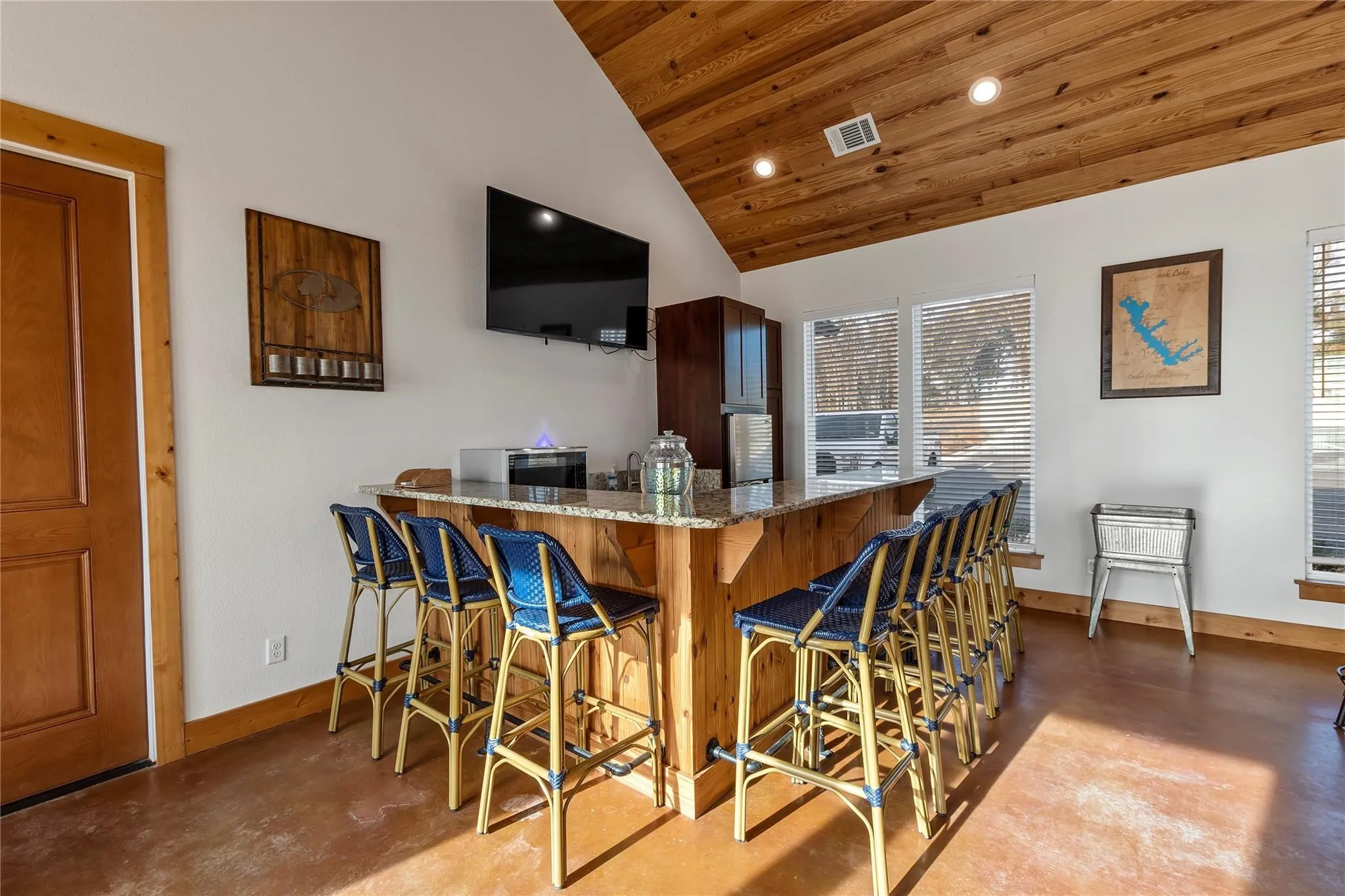 Community entertaining space with ample seating, kitchenette area, and beautiful natural light throughout.