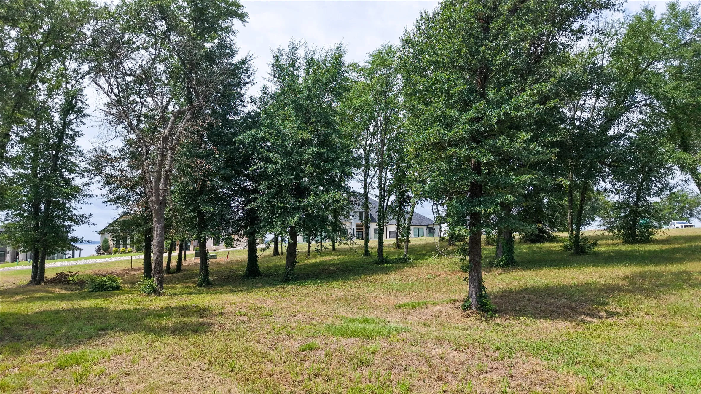 Lot view showcasing beautiful homes and the lake located across the street