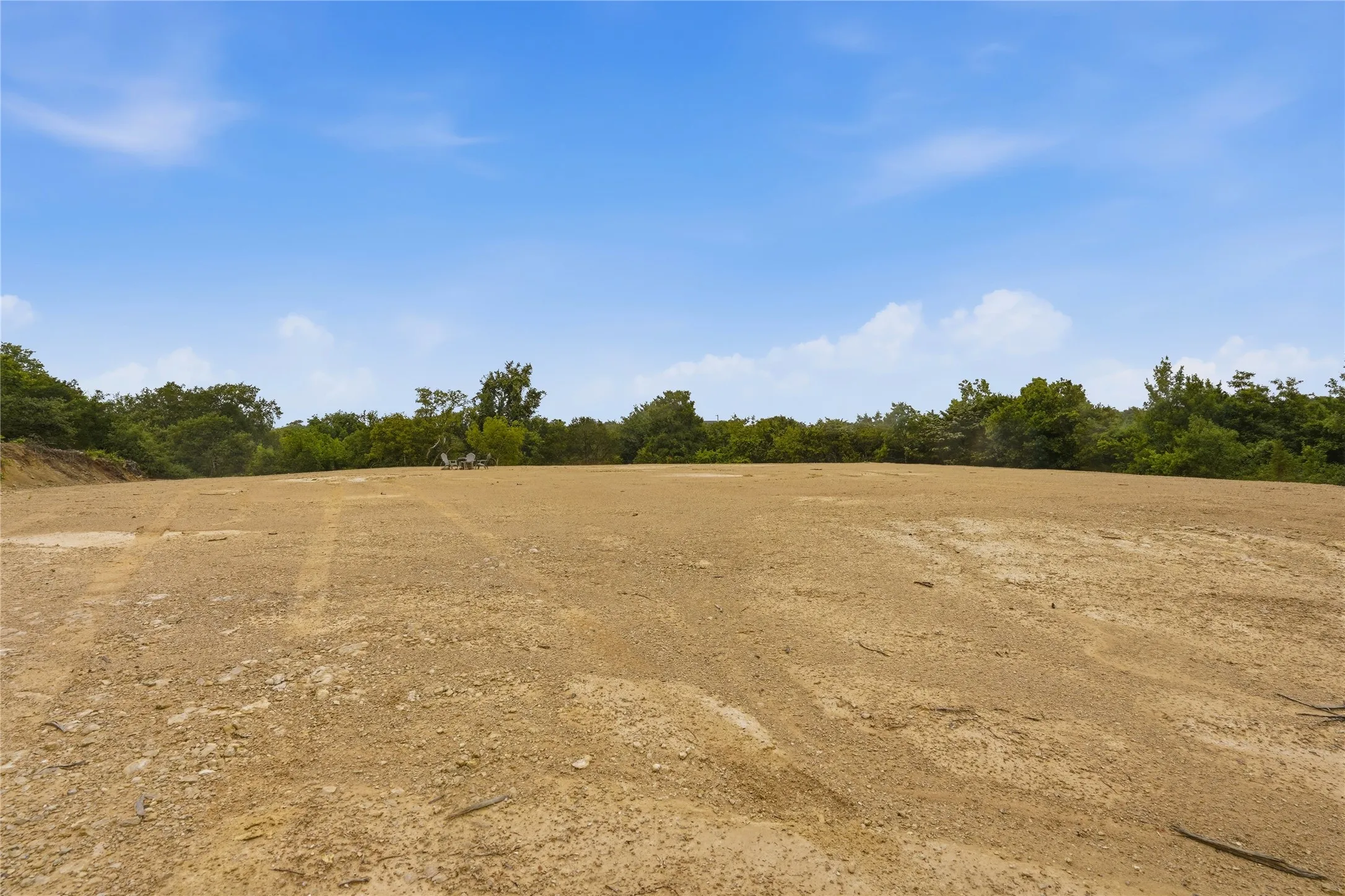 Expansive cleared lot with a natural tree line perimeter, presenting a significant building envelope