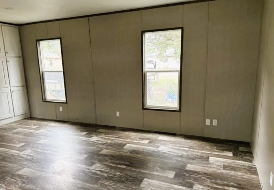 Stylish flooring elevates the living area with built-in cabinets at left for storage.