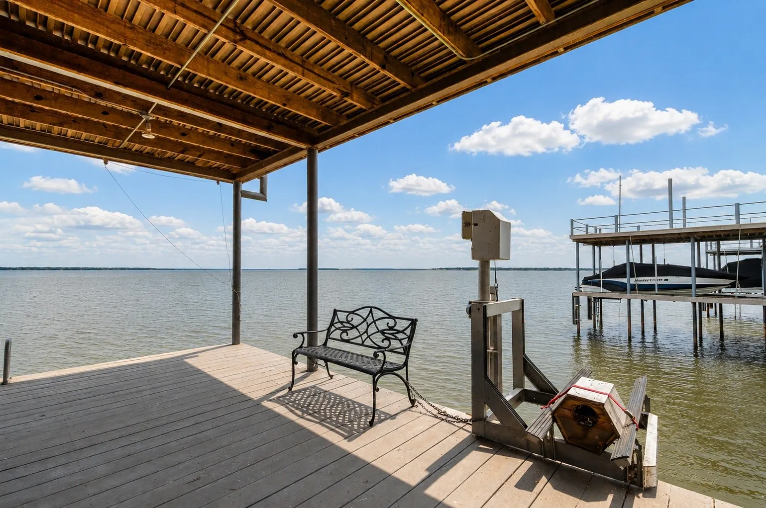 Covered Sitting Area on lower level of boat house with PWC Lift