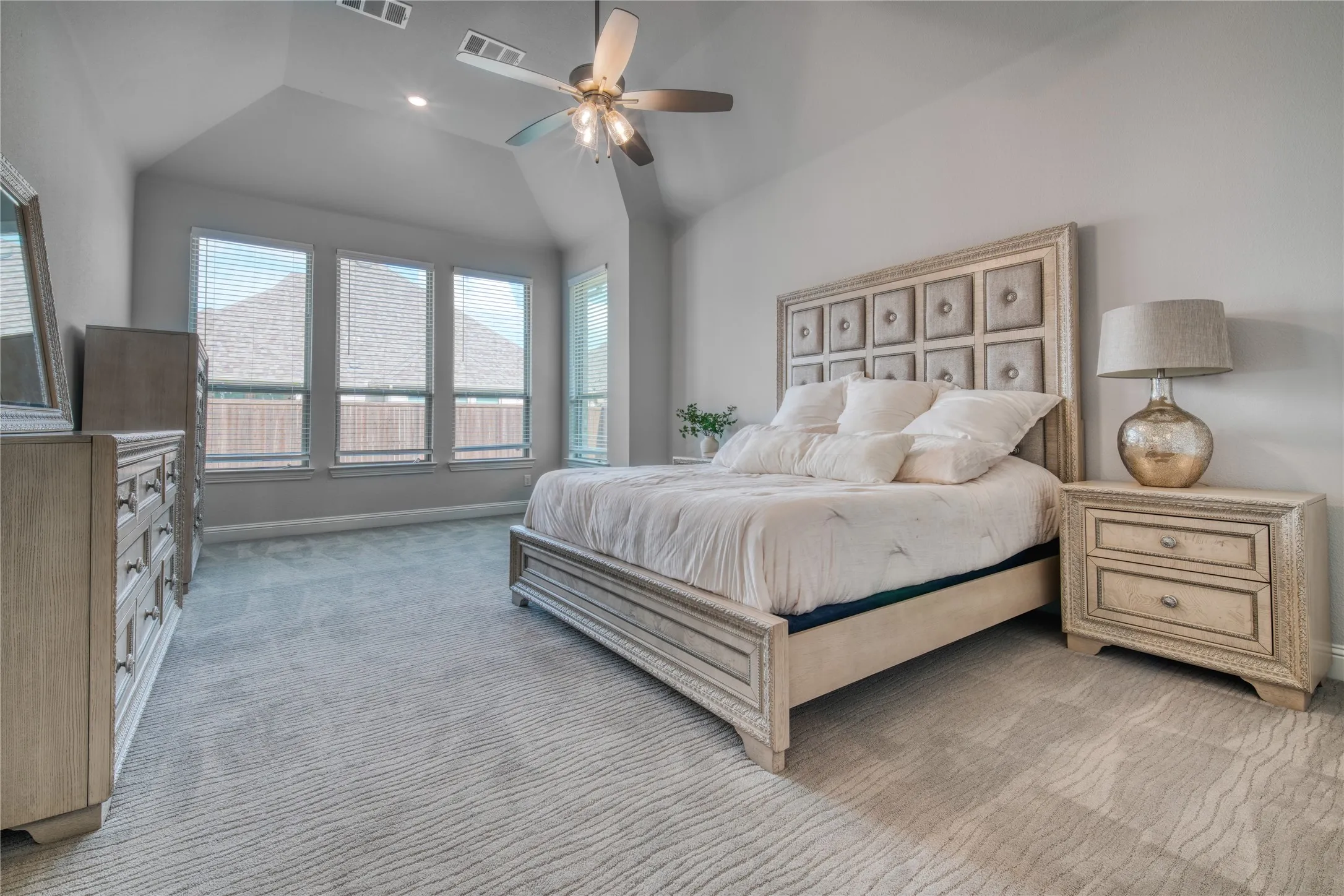 Bedroom featuring light colored carpet, vaulted ceiling, a ceiling fan, and recessed lighting