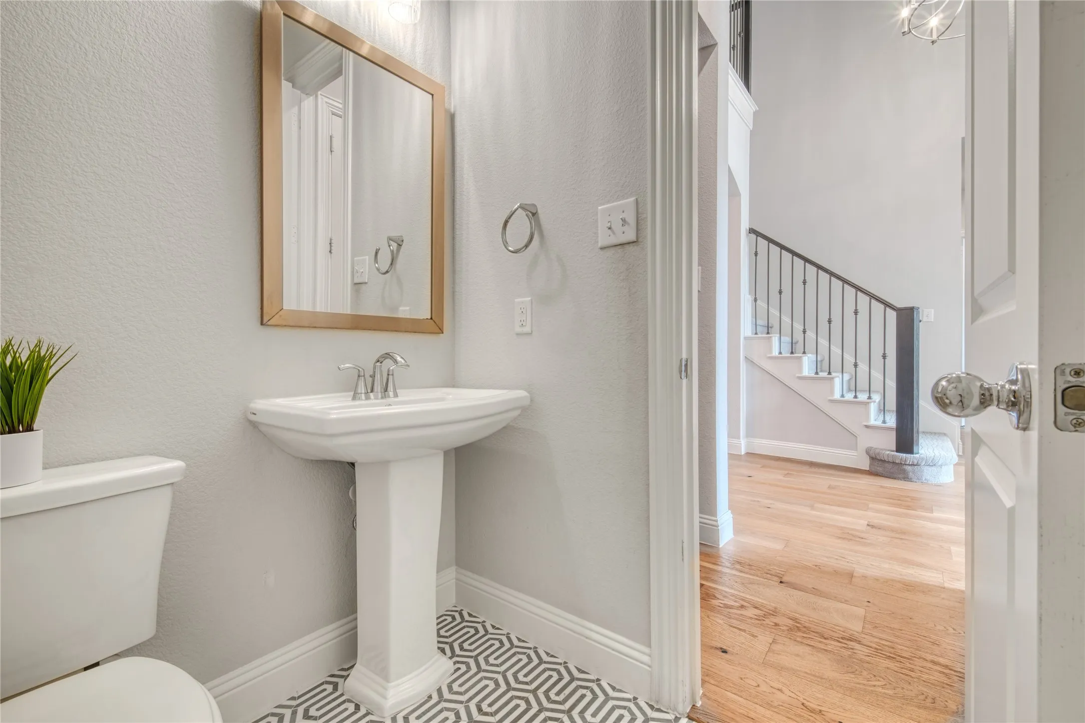 Half bathroom featuring a textured wall and wood finished floors