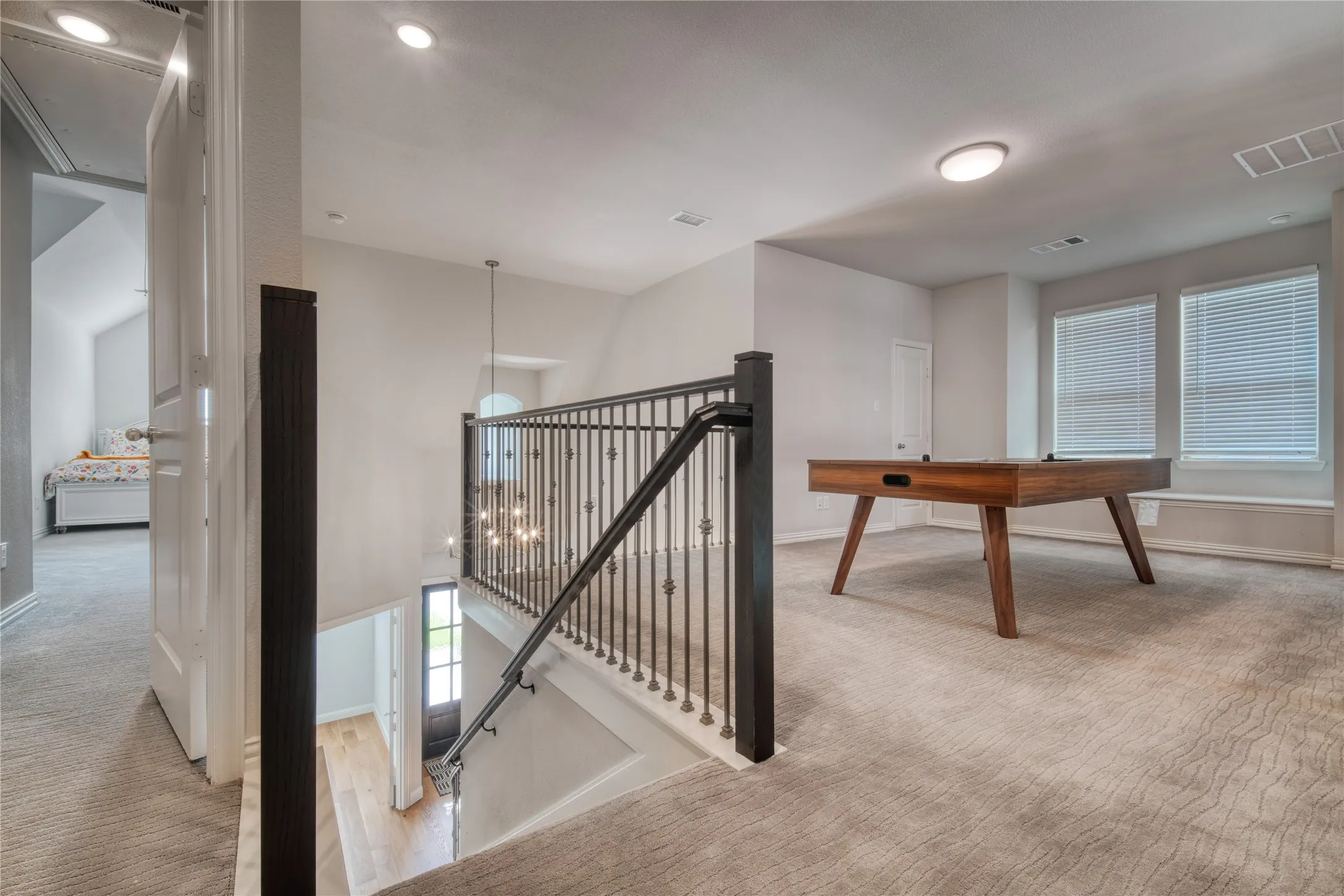 Hallway featuring an upstairs landing, carpet floors, a chandelier, and wood finished floors