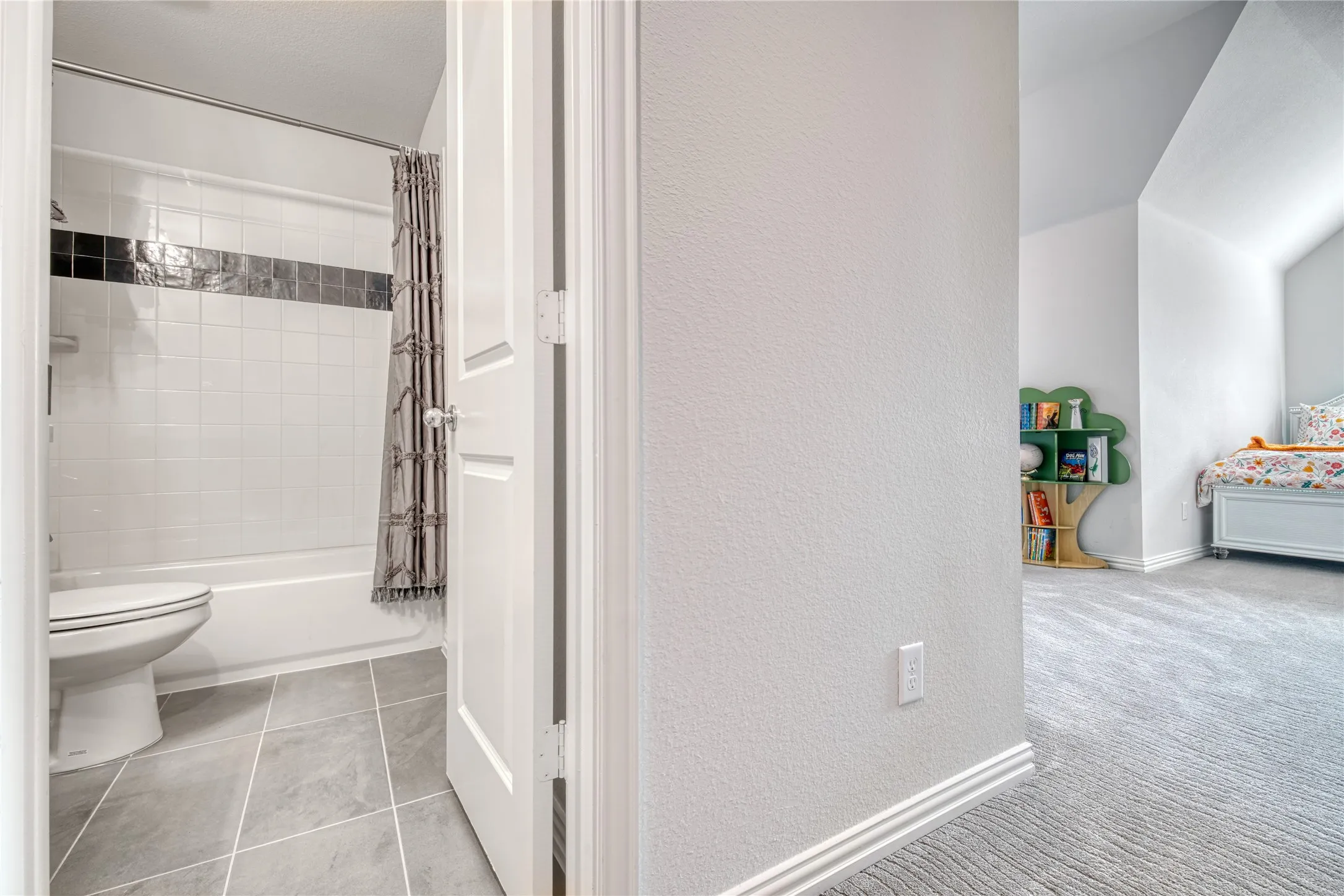 Full bathroom with a textured wall and shower / bathtub combination with curtain