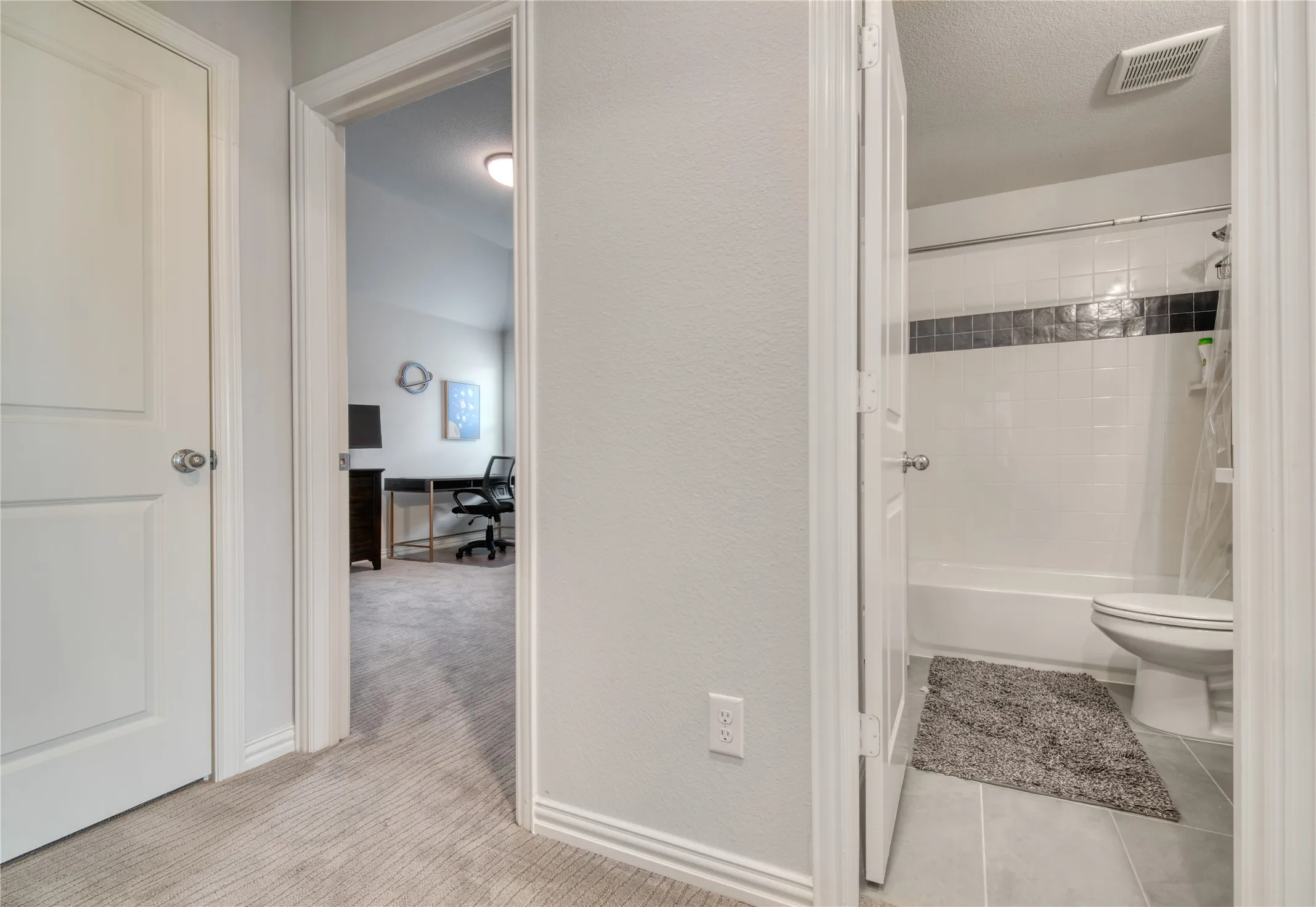 Bathroom featuring washtub / shower combination, a textured wall, a textured ceiling, and tile patterned flooring