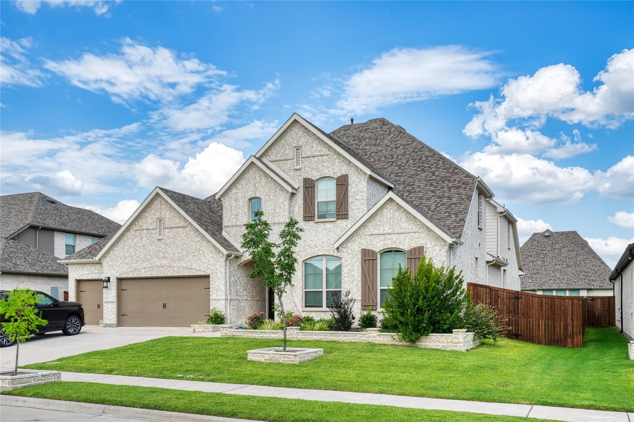 French country style house featuring concrete driveway, brick siding, a shingled roof, and a garage