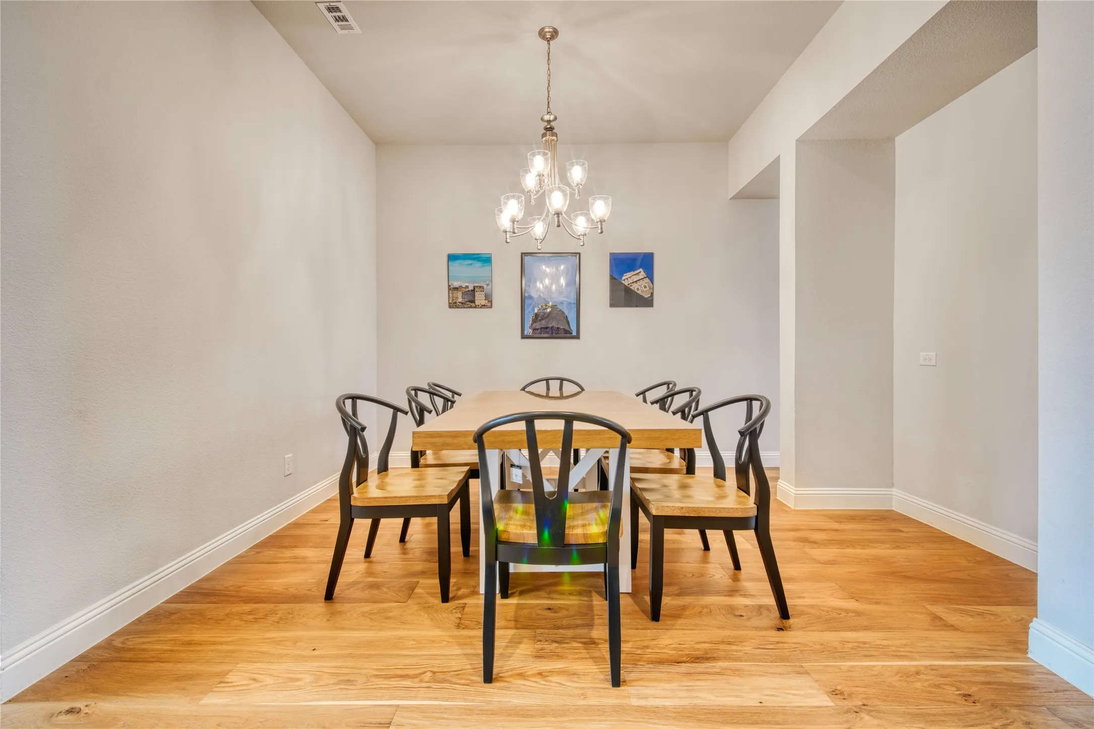 Dining space with light wood-style floors and a chandelier