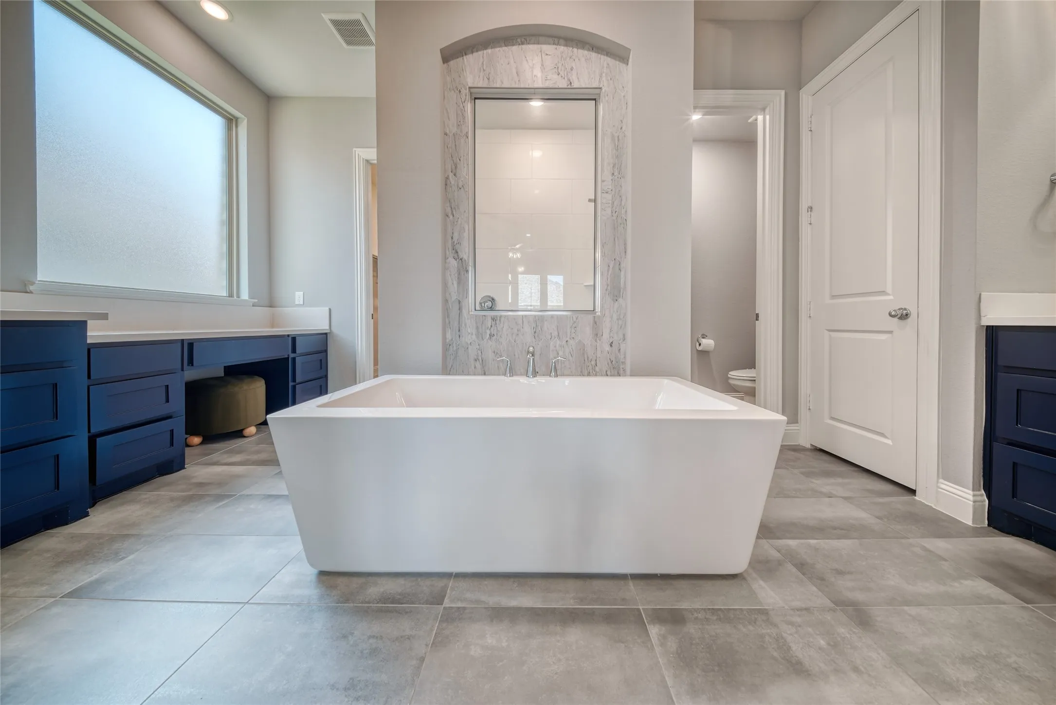 Full bathroom with a soaking tub, vanity, and recessed lighting