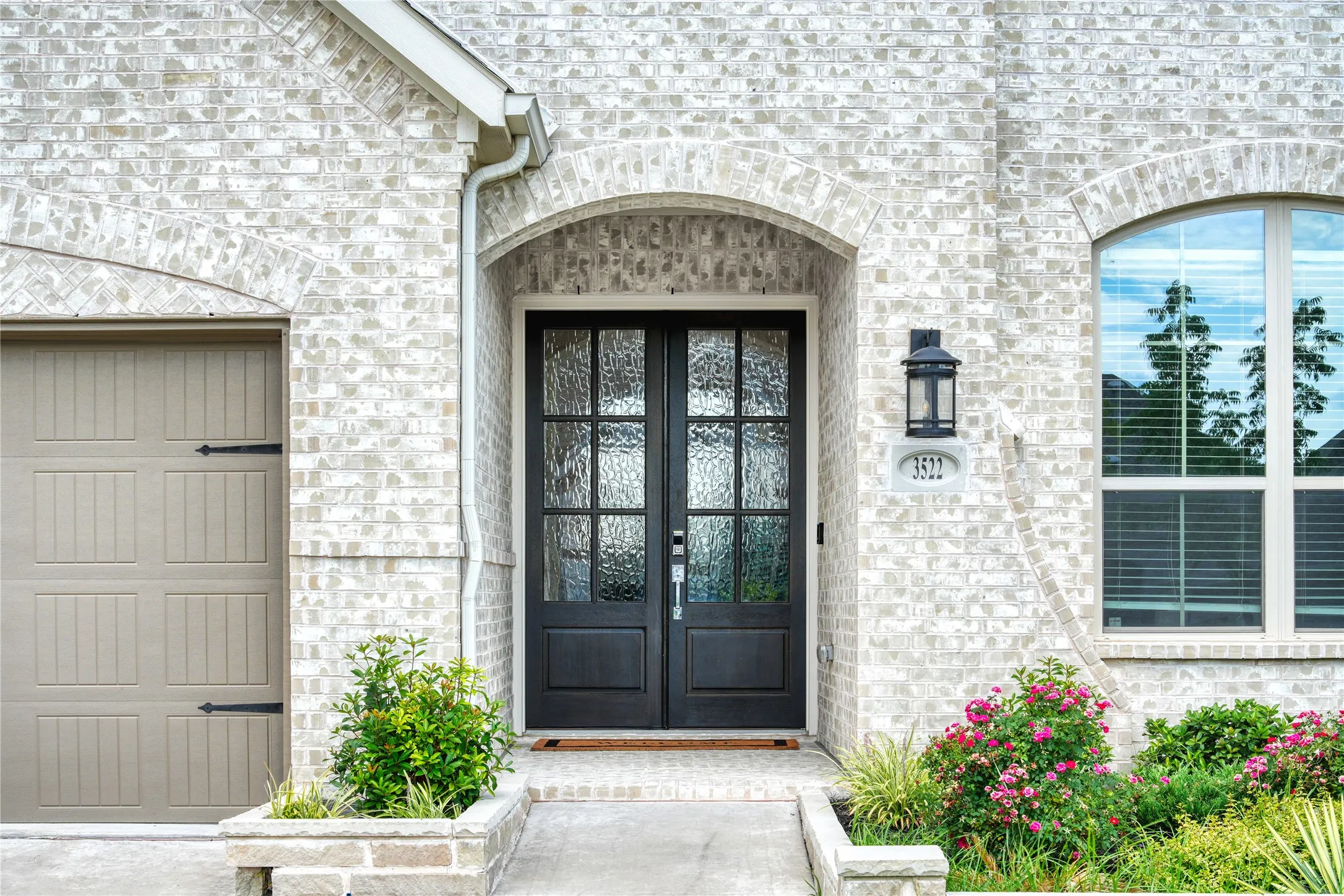 Property entrance with stone siding, french doors, and brick siding