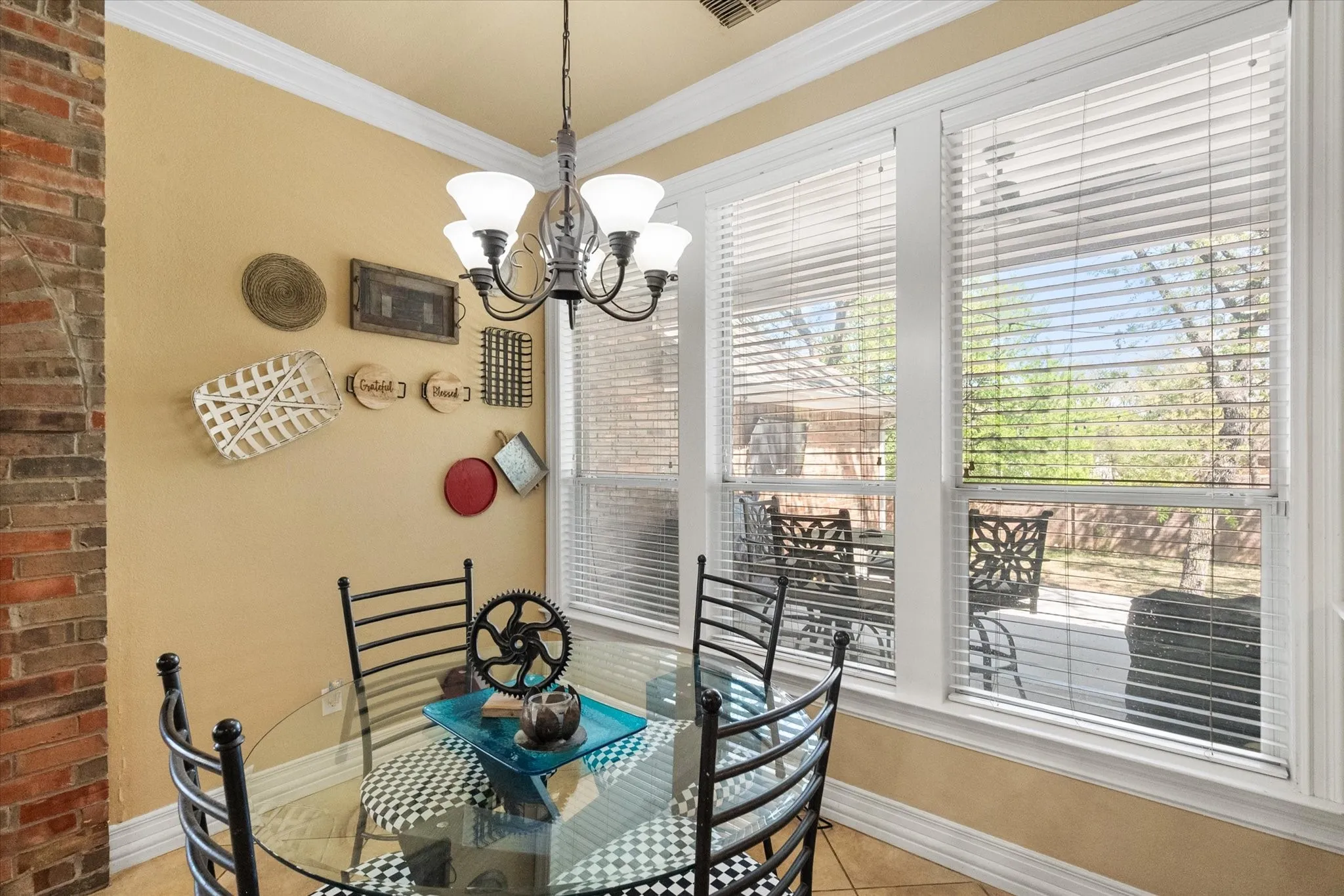 Breakfast room with wall of windows streaming natural light into the area. The breakfast room has expansive views of the backyard. Notice the crown molidng detail.