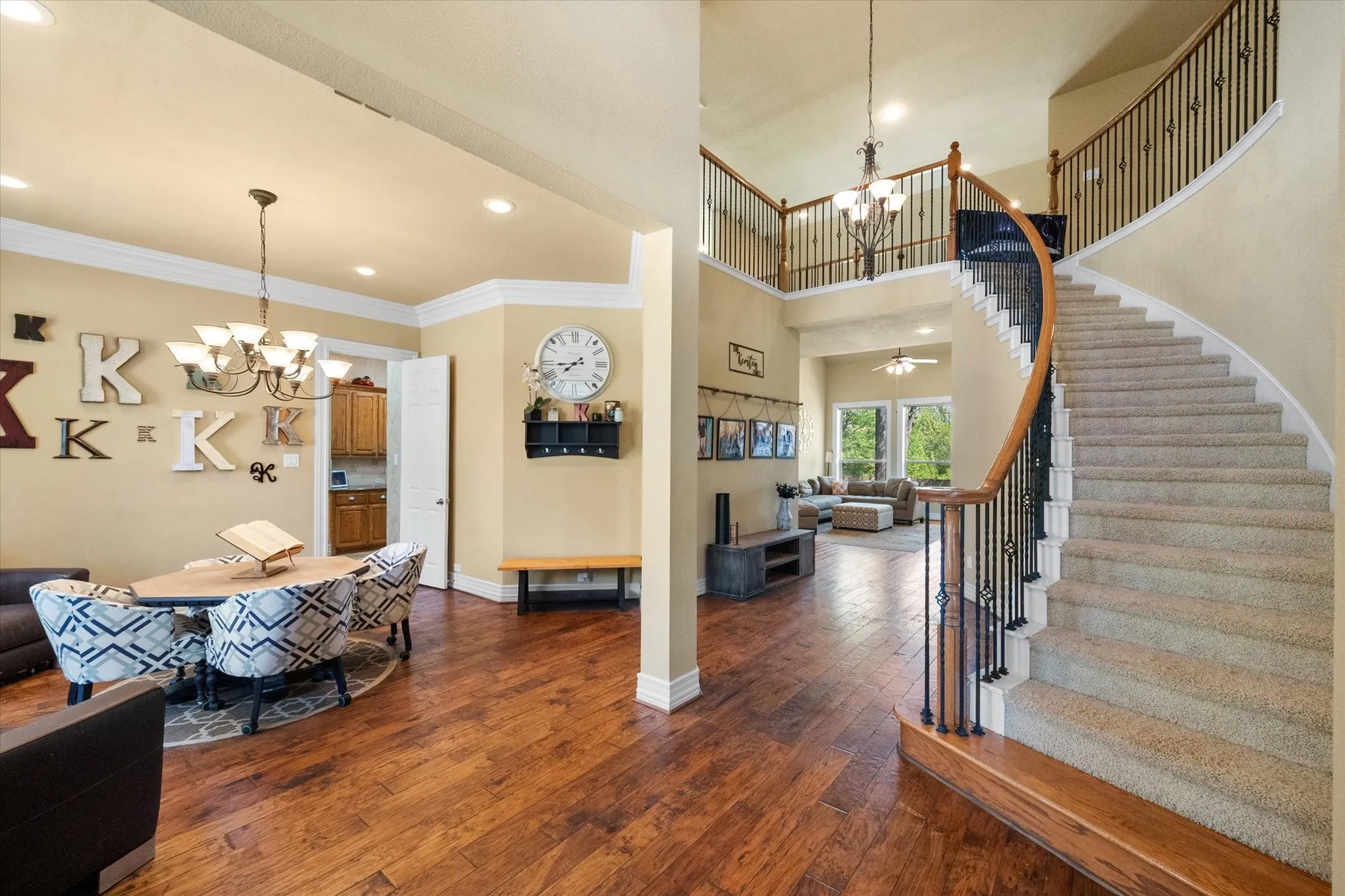 Impressive **grand entry with rich wood flooring** welcomes you into this beautifully designed home featuring a **sweeping staircase with wrought iron spindles and wood handrail**. The open-concept layout is enhanced by **soaring ceilings, crown molding, and abundant natural light**, creating a bright and inviting first impression. This elegant foyer seamlessly connects to the main living areas, offering the perfect blend of **architectural detail, openness, and functionality**—ideal for both everyday living and entertaining.