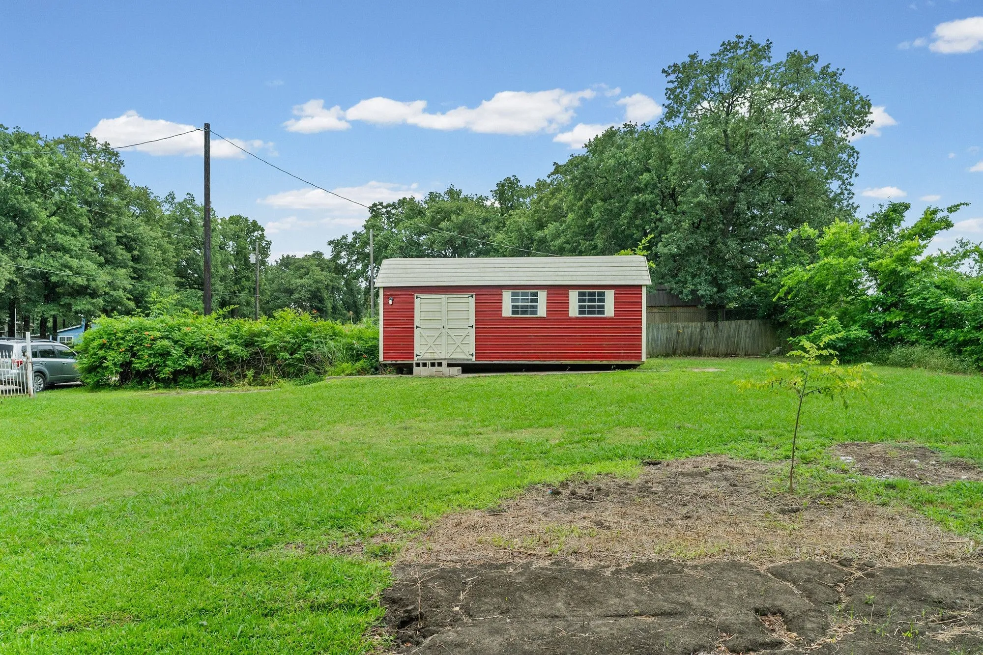 Red storage shed with white trim and double doors