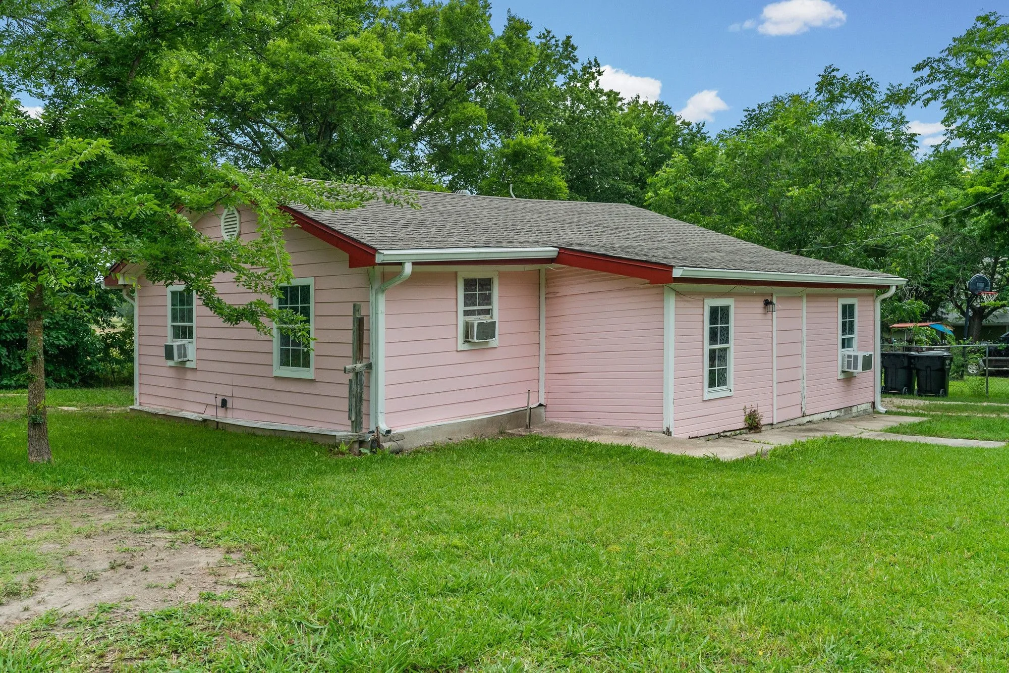 Pink exterior siding with white window trim