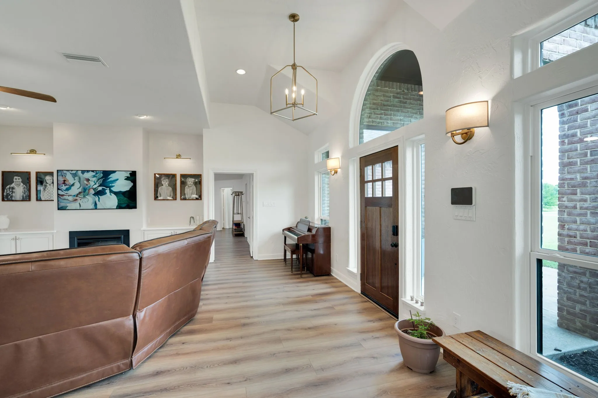 Welcoming entryway with a dark wood-paneled door, arched transom window, and sidelights