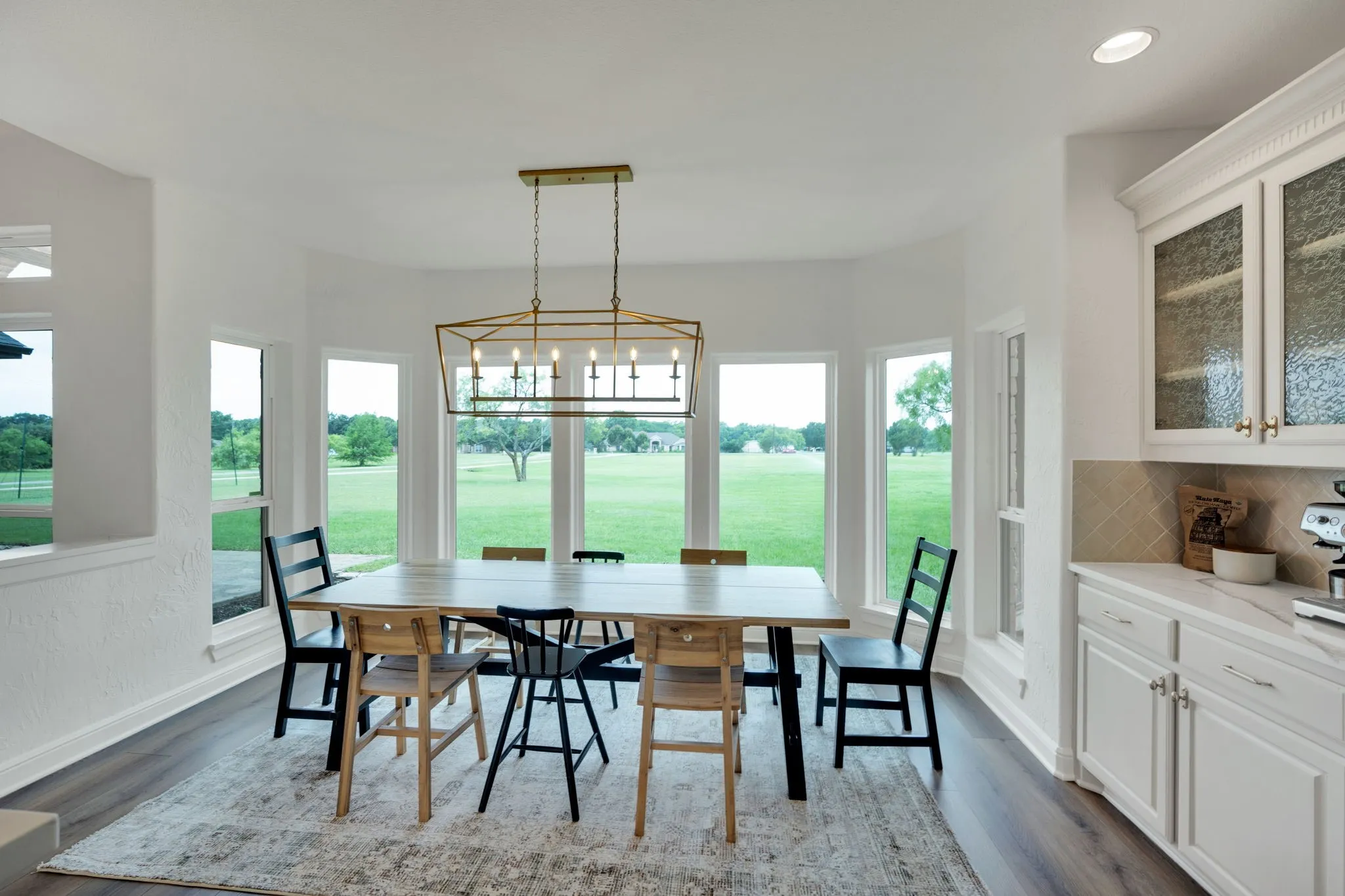 Bay window dining area featuring expansive exterior views and a modern linear chandelier