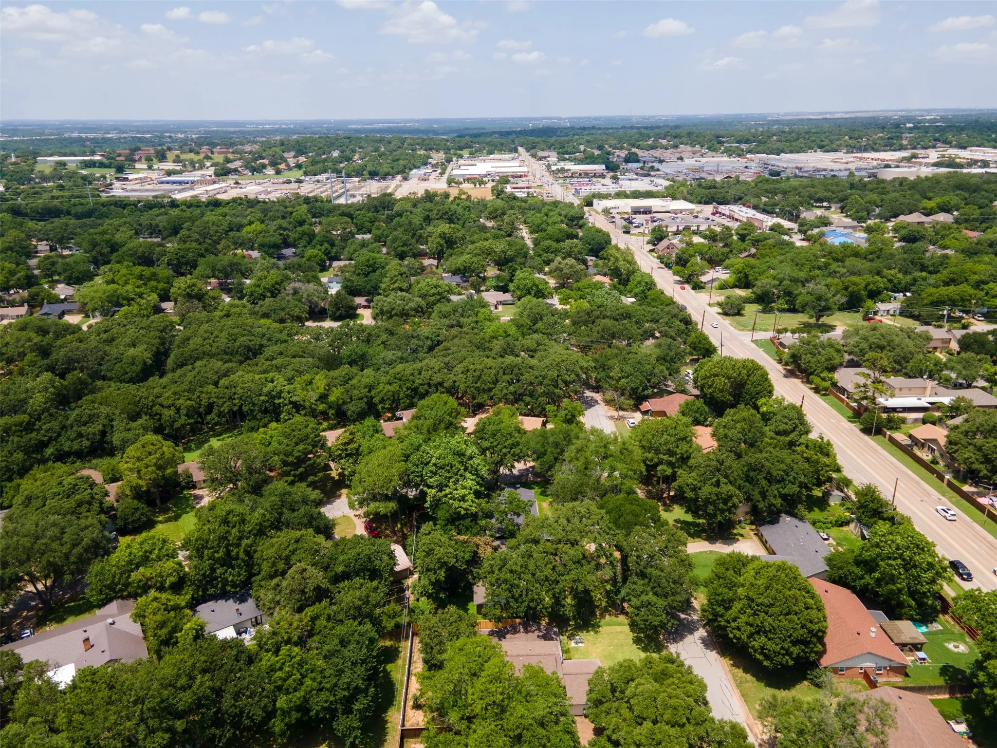 Aerial perspective showcasing an expansive residential area with abundant mature tree cover