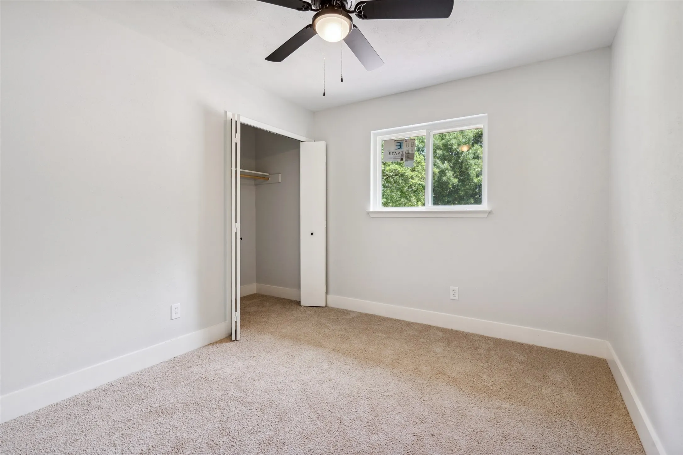 Room featuring neutral-toned carpeting, light gray wall paint, and white baseboards