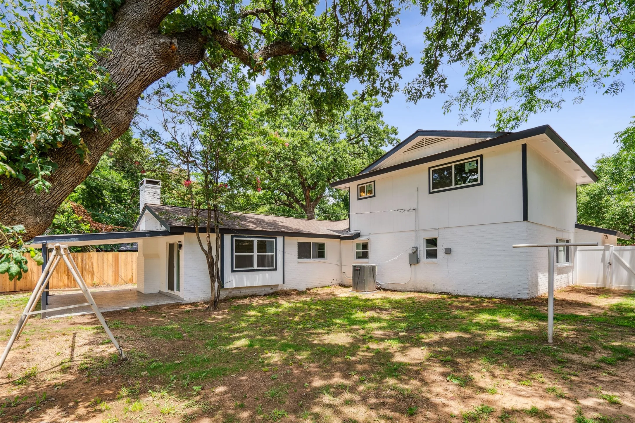 Rear exterior showcasing a white brick facade with black trim accents and a multi-level roofline