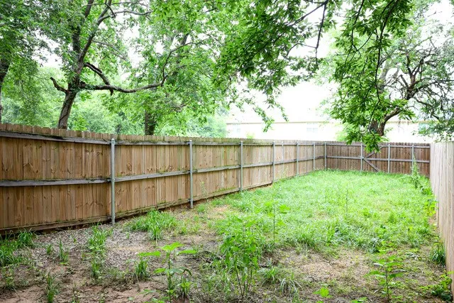 Private backyard space with wood fencing and mature perimeter trees