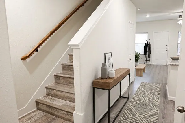 Staircase with wood-finish treads and risers, complemented by a natural wood handrail