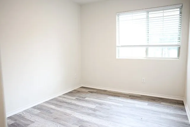 Room featuring light wood-finish flooring, white baseboards, and neutral wall paint