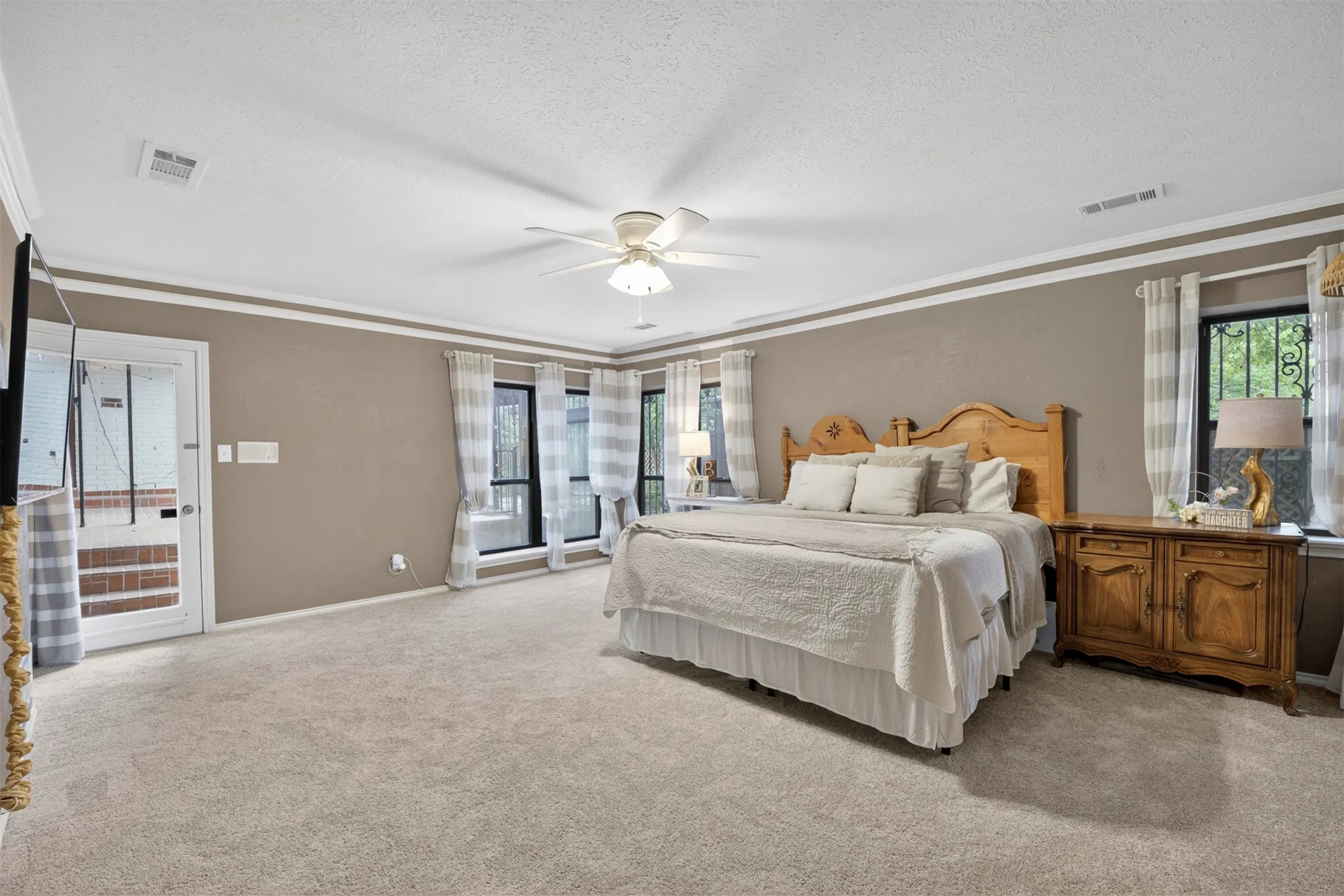 Spacious room featuring carpeting, neutral wall colors, crown molding, and a ceiling fan