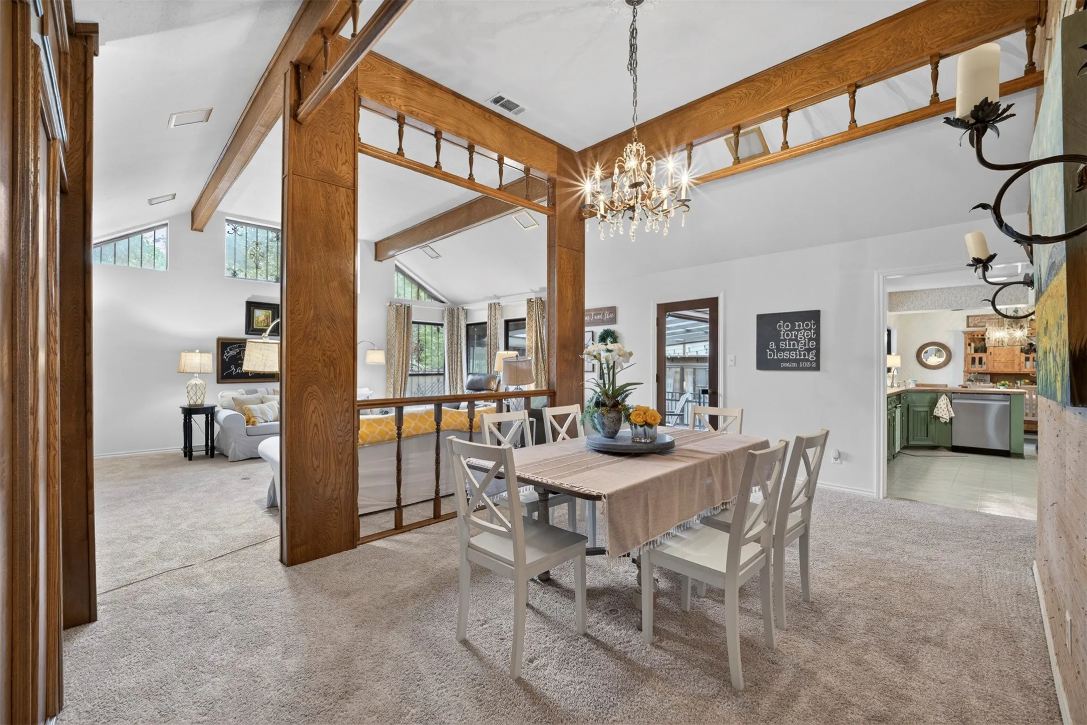 Dining area featuring a crystal chandelier, wood-finish beams, and carpet flooring
