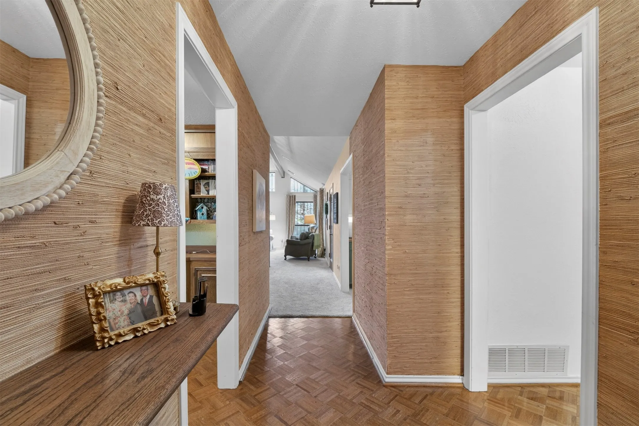 Hallway featuring grasscloth wall coverings and parquet wood-finish flooring