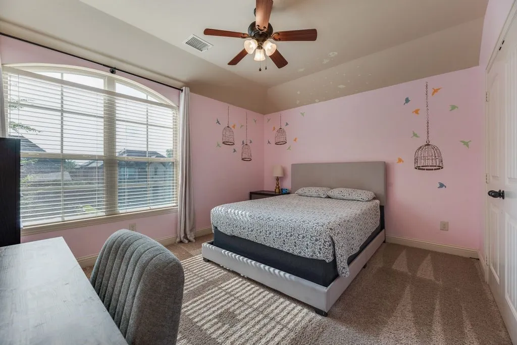 Bedroom 3 featuring a large arched window with blinds, a ceiling fan with light, and carpeted flooring