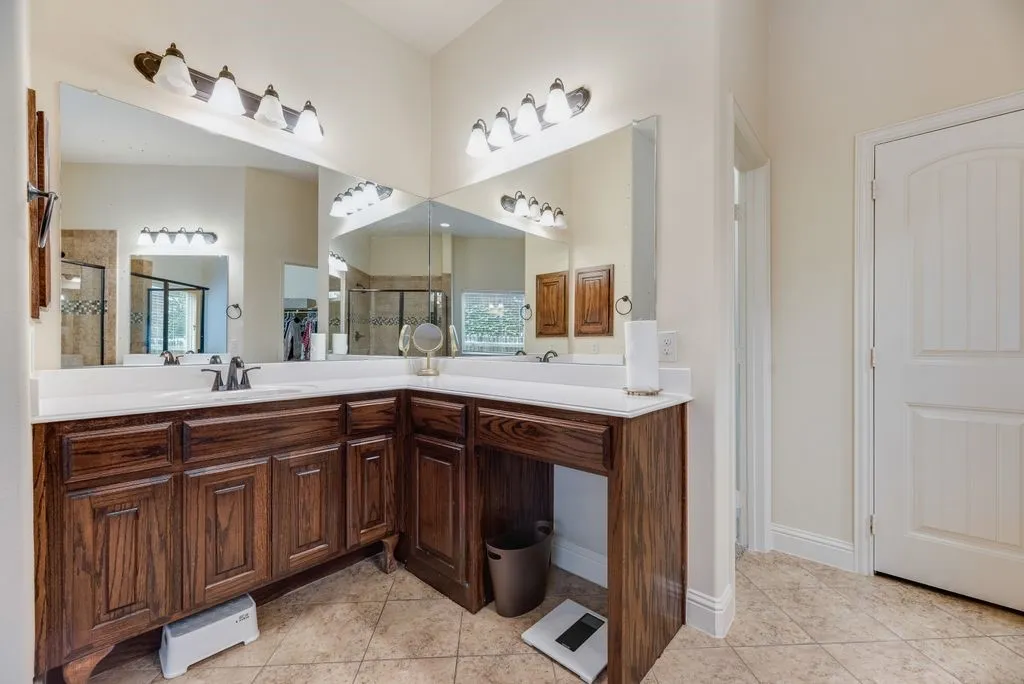 Bathroom featuring a dual vanity with dark wood cabinetry, white countertops, and integrated sinks