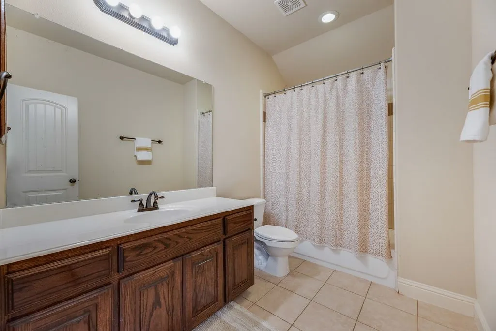Bathroom featuring a dark wood-finish vanity with a white countertop and integrated sink located between Bed 2 and Bed 3