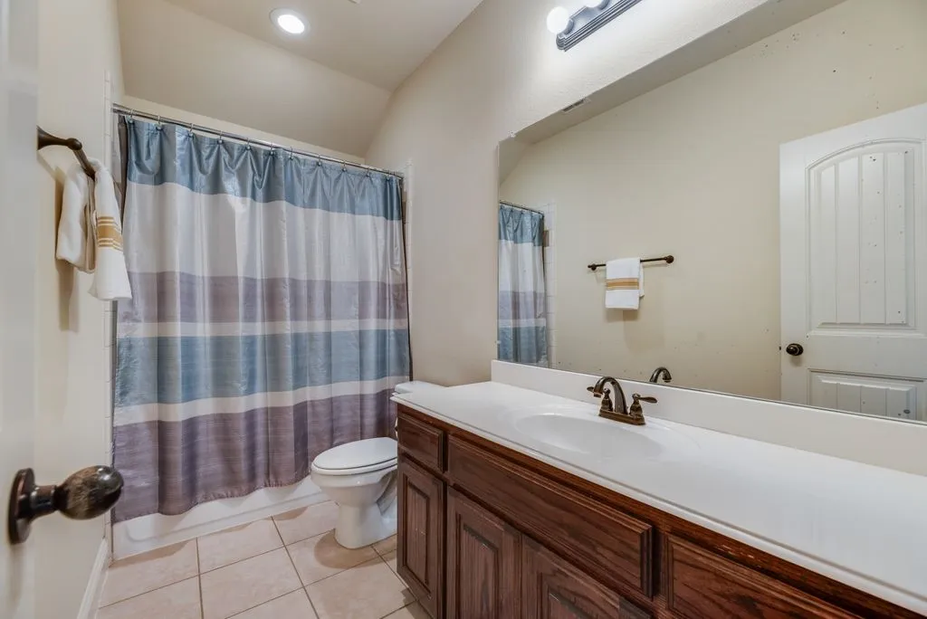 Bathroom featuring a built-in wood-finish vanity, integrated sink, and bronze-finish faucet adjacent to bed 4