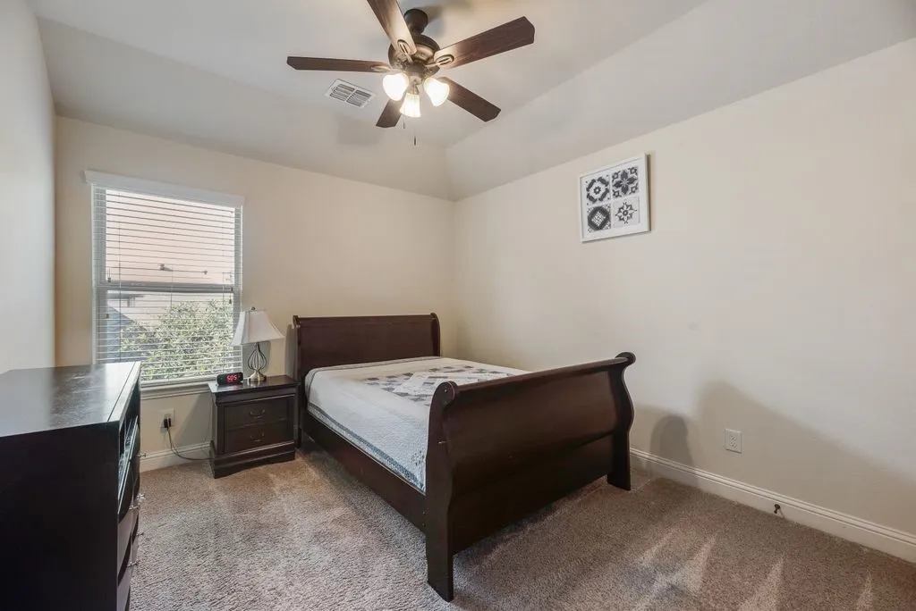 Bedroom 4 featuring neutral-toned walls, recessed window with blinds, and a ceiling fan with integrated lighting