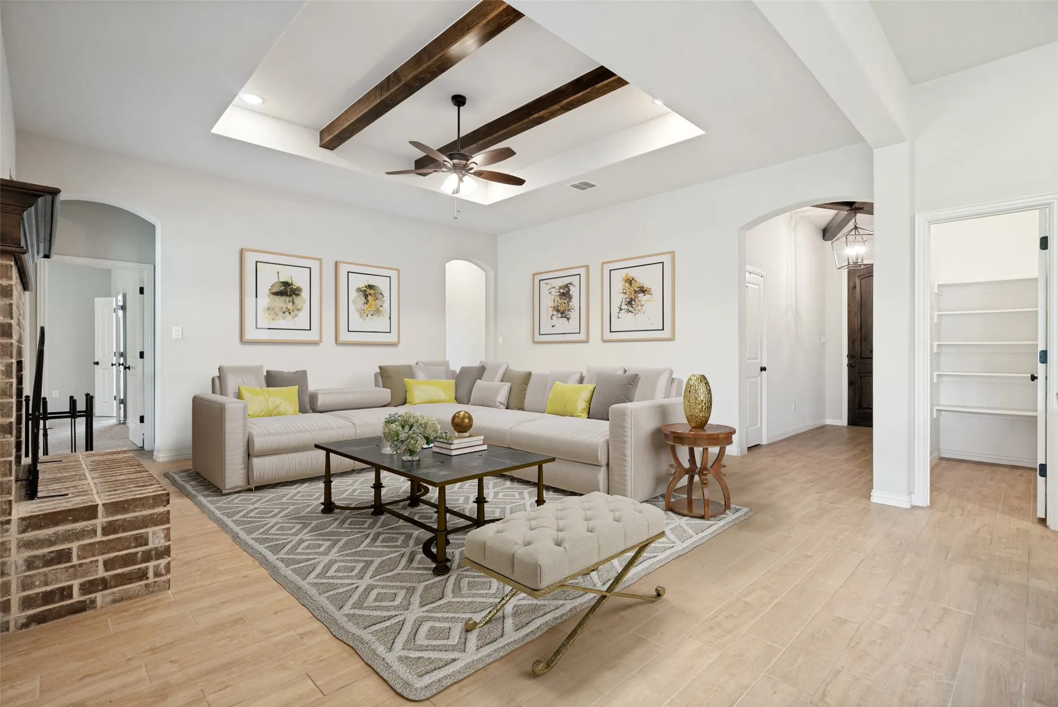 Spacious living area featuring a tray ceiling with exposed wood beams, a ceiling fan, and recessed lighting