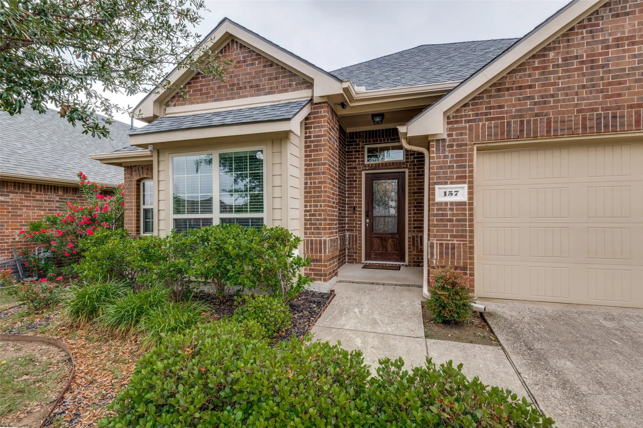 Nicely Landscaped covered front porch features upgraded front door