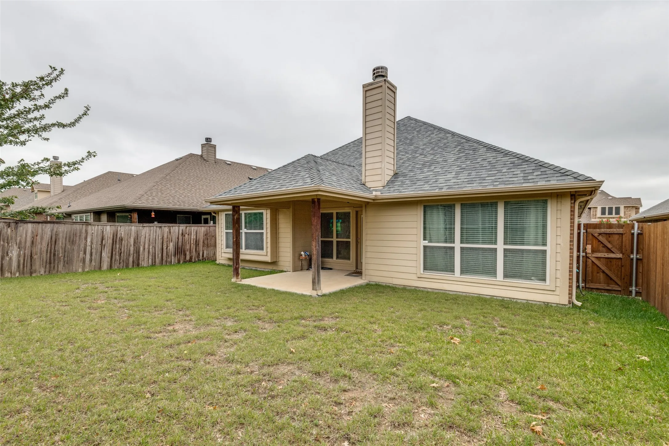 Back Yard view with covered patio, sprinkler and gutters, side gate, roof recently replaced.