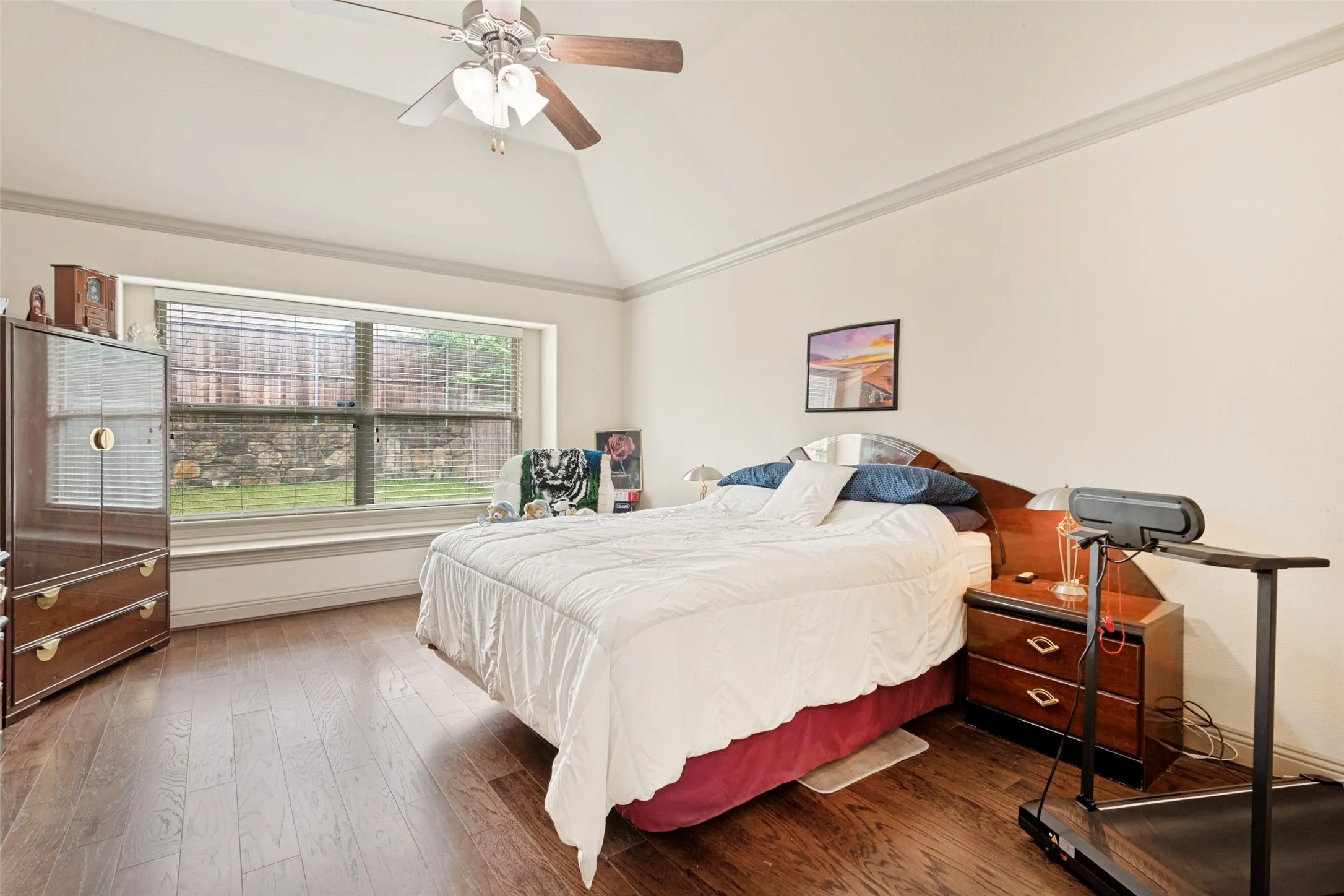 Master wall of windows and bench seating wood flooring ceiling fan tray ceiling with crown molding.