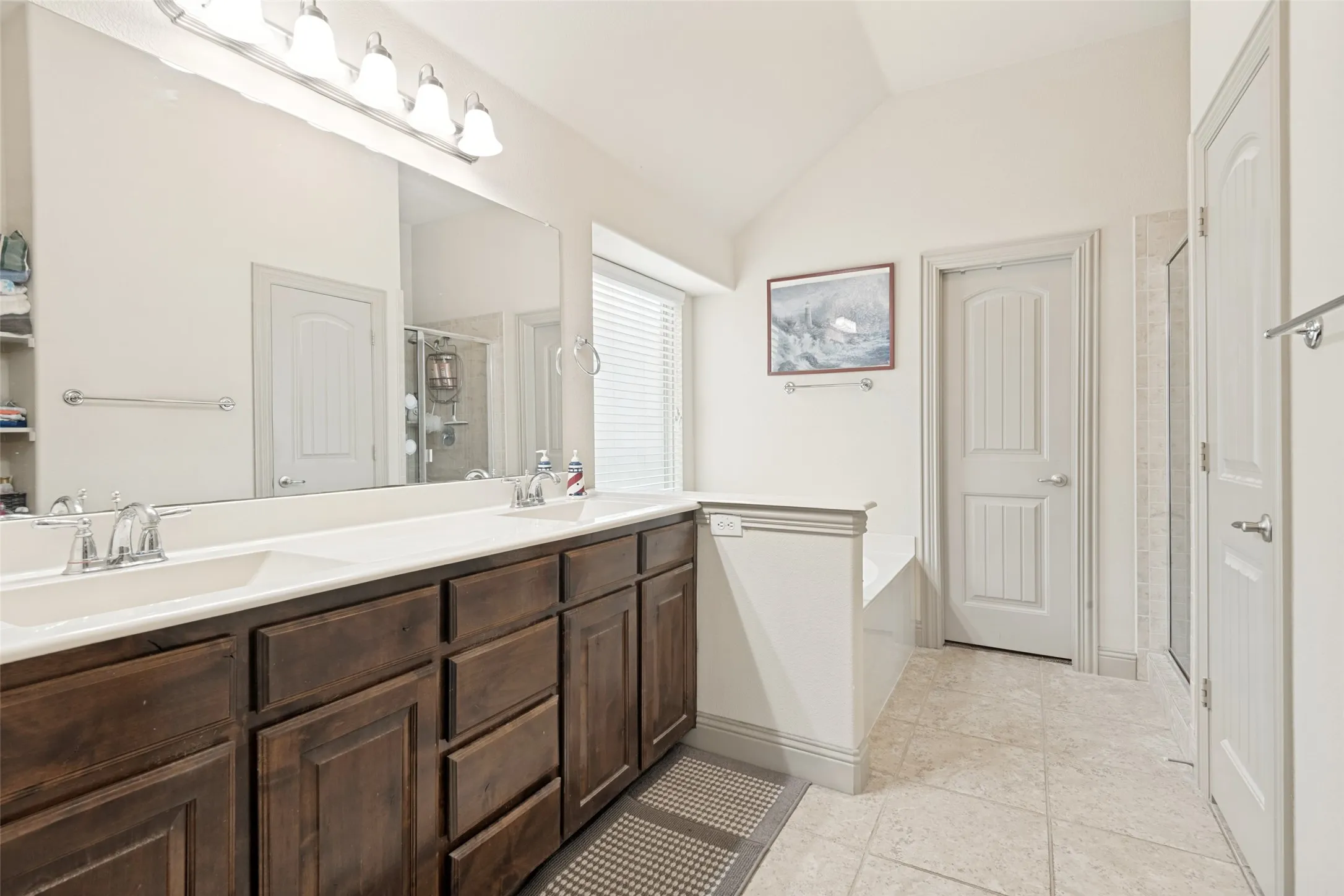 Nice large vanity duel sinks great storage ,shows view of doors leading into walk in closet and toilet room