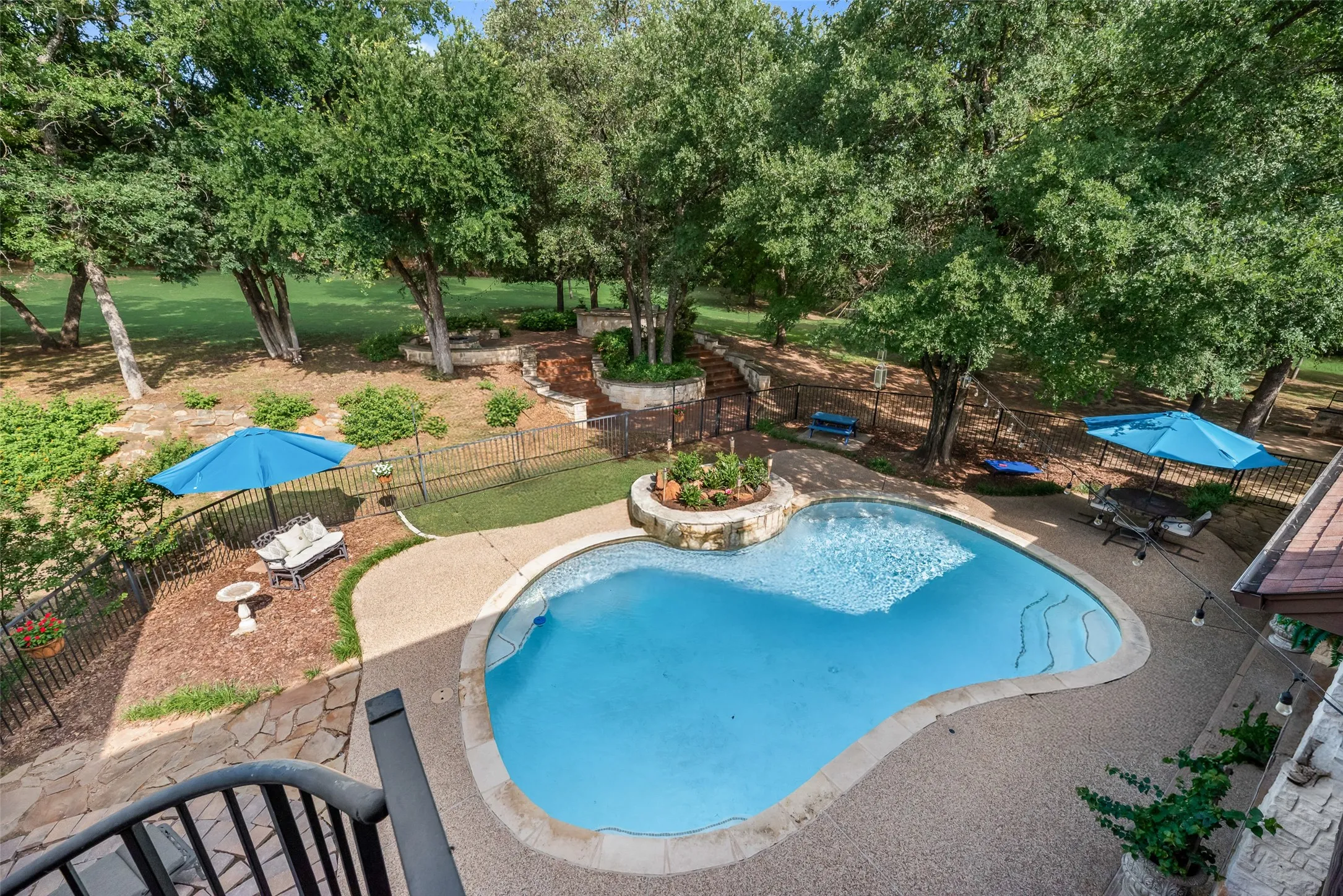 Freeform swimming pool featuring a stone surround and integrated planter