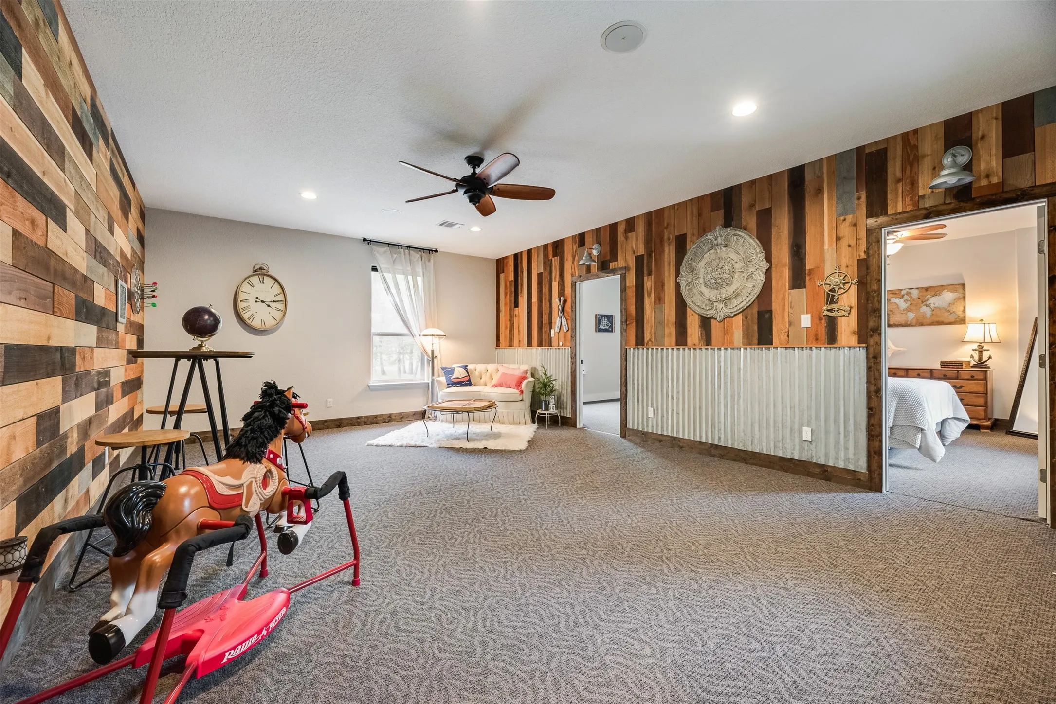 Spacious room featuring patterned carpet, wood-paneled walls, and recessed lighting