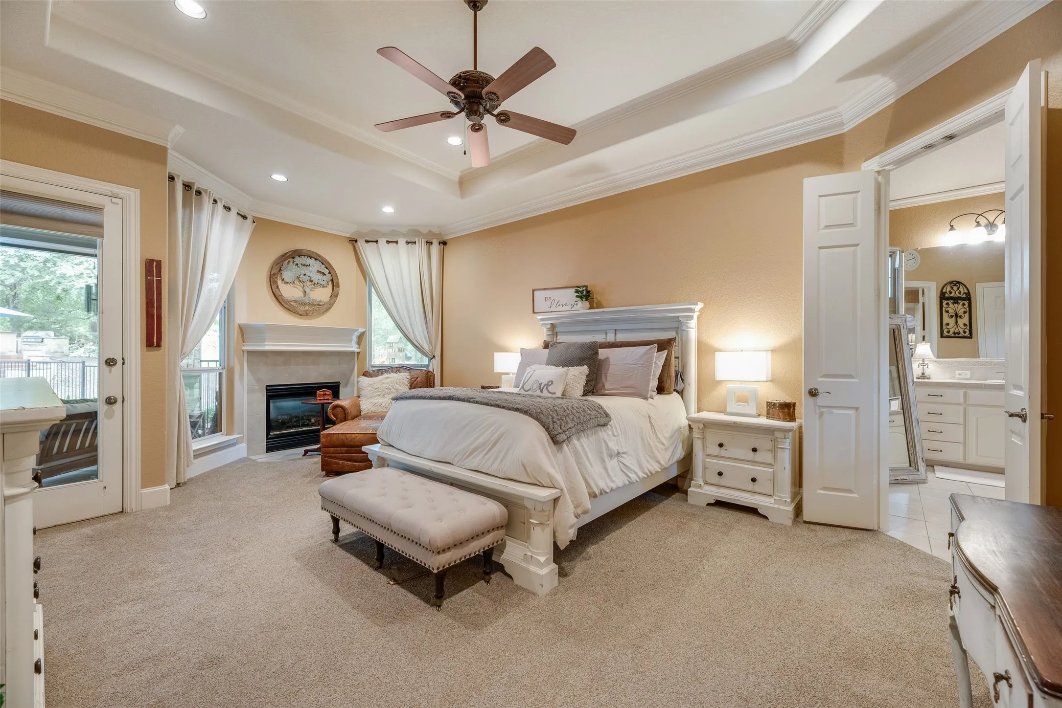 Recessed lighting illuminates a tray ceiling and ceiling fan
