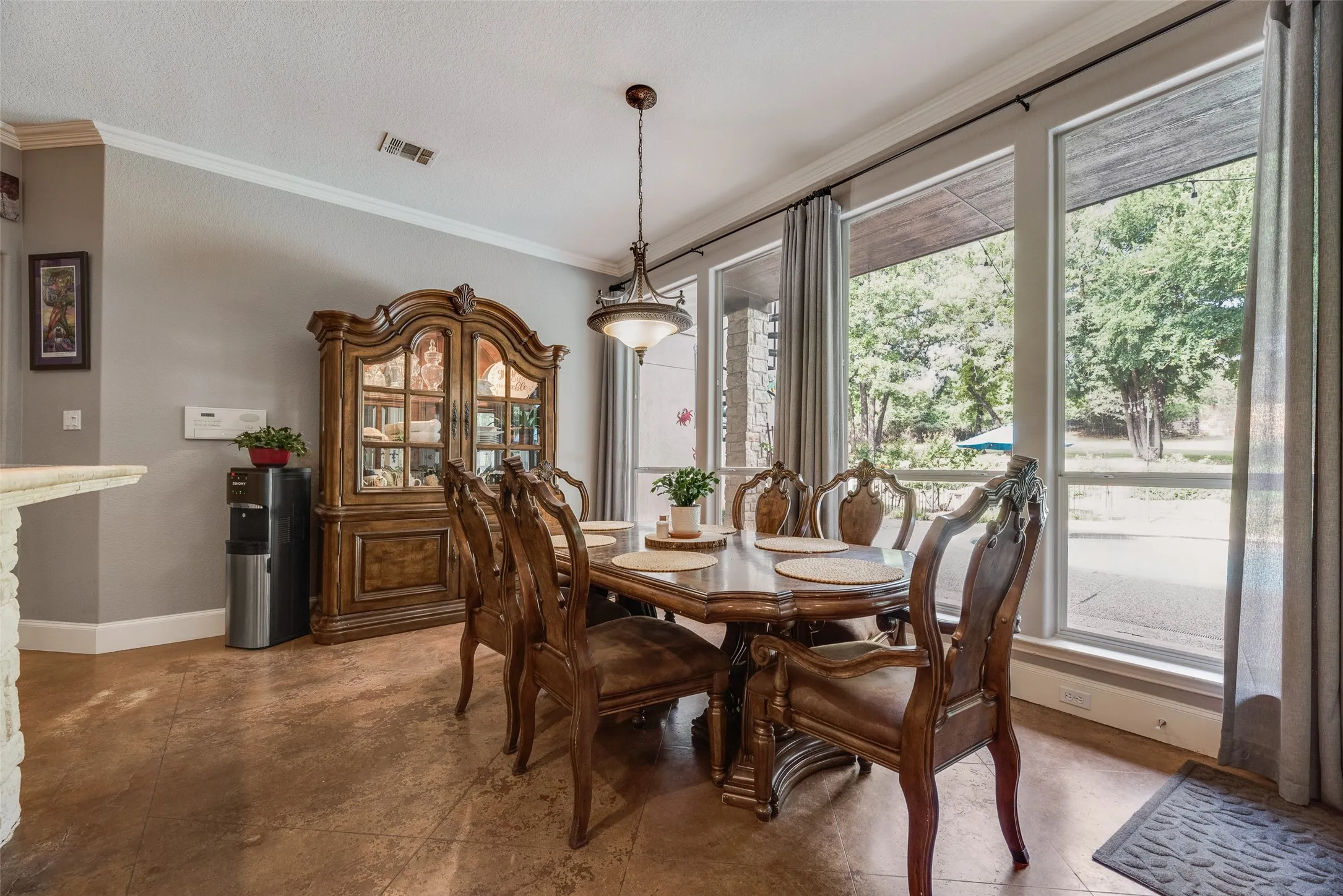 Dining area featuring expansive windows, crown molding, and sconce lighting