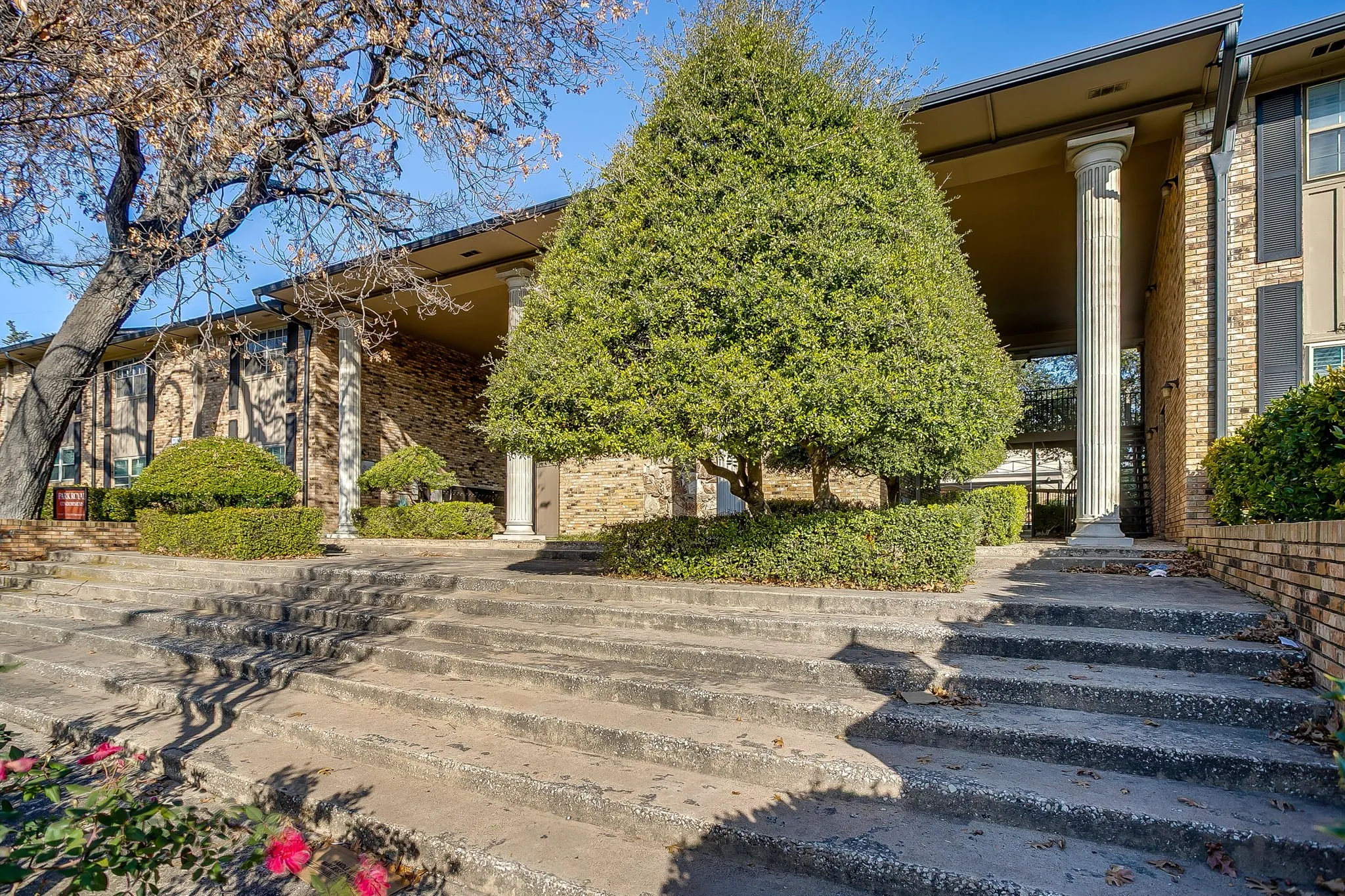 Brick exterior featuring a covered entryway with architectural columns